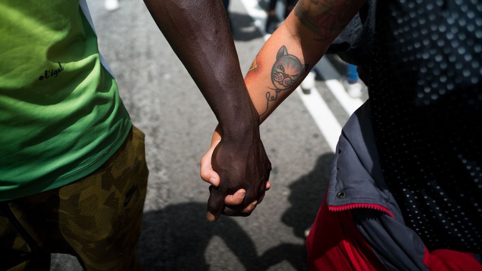 Dues persones es donen la mà durant una concentració contra el racisme