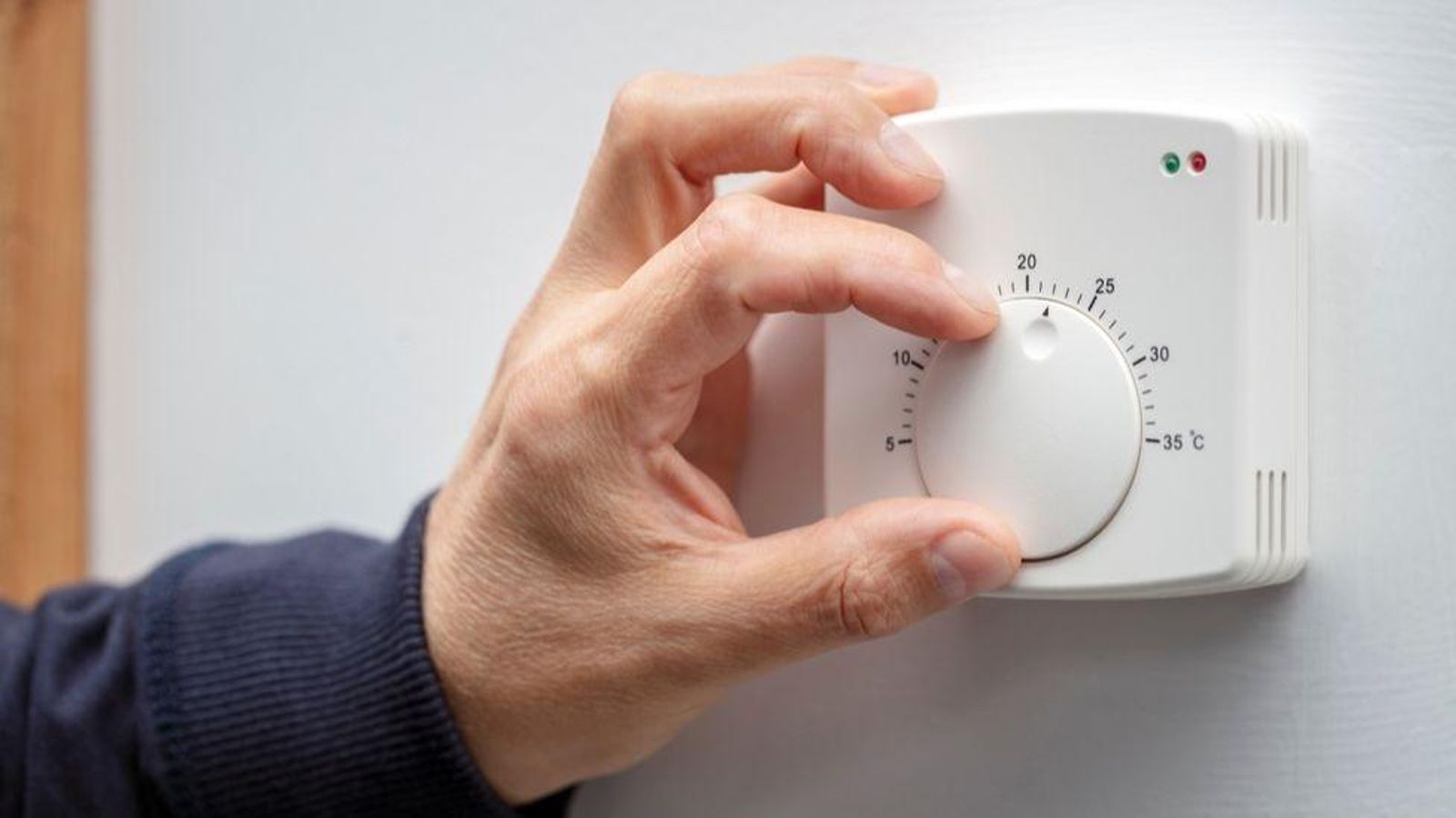 Persona regulant la temperatura del termostat