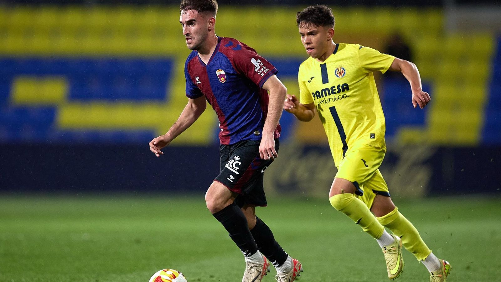 Un jugador de l'Eldense i un del Villarreal B, en una acció del duel