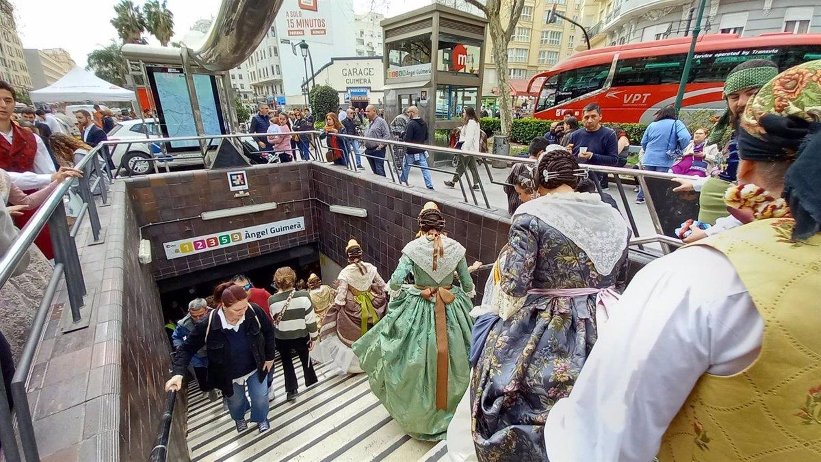 Un grup de falleres i fallers entren a la parada de Metrovalencia d'Àngel Guimerà