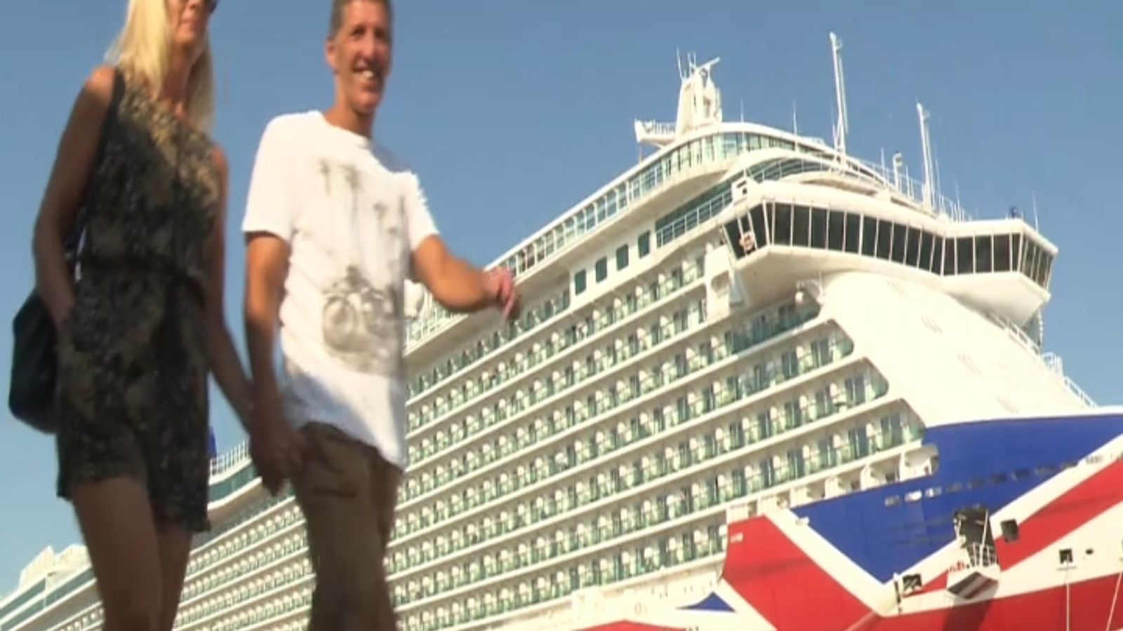 Dos dels creueristes amb el Britannia de fons