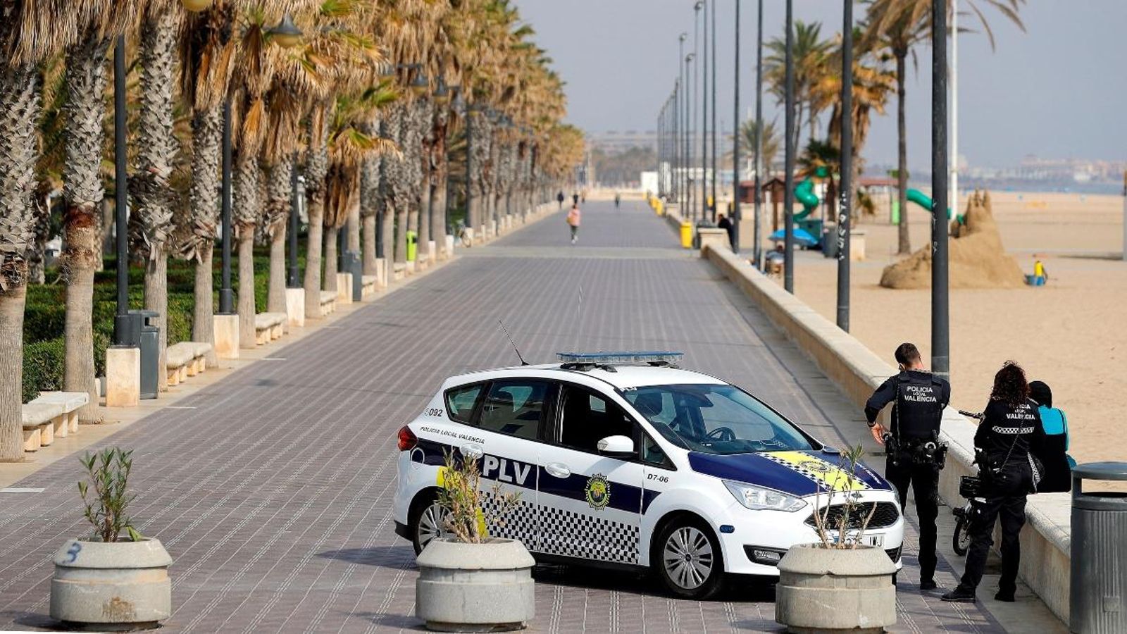 Un cotxe de la Policia Local de València patrulla el passeig marítim aquest diumenge