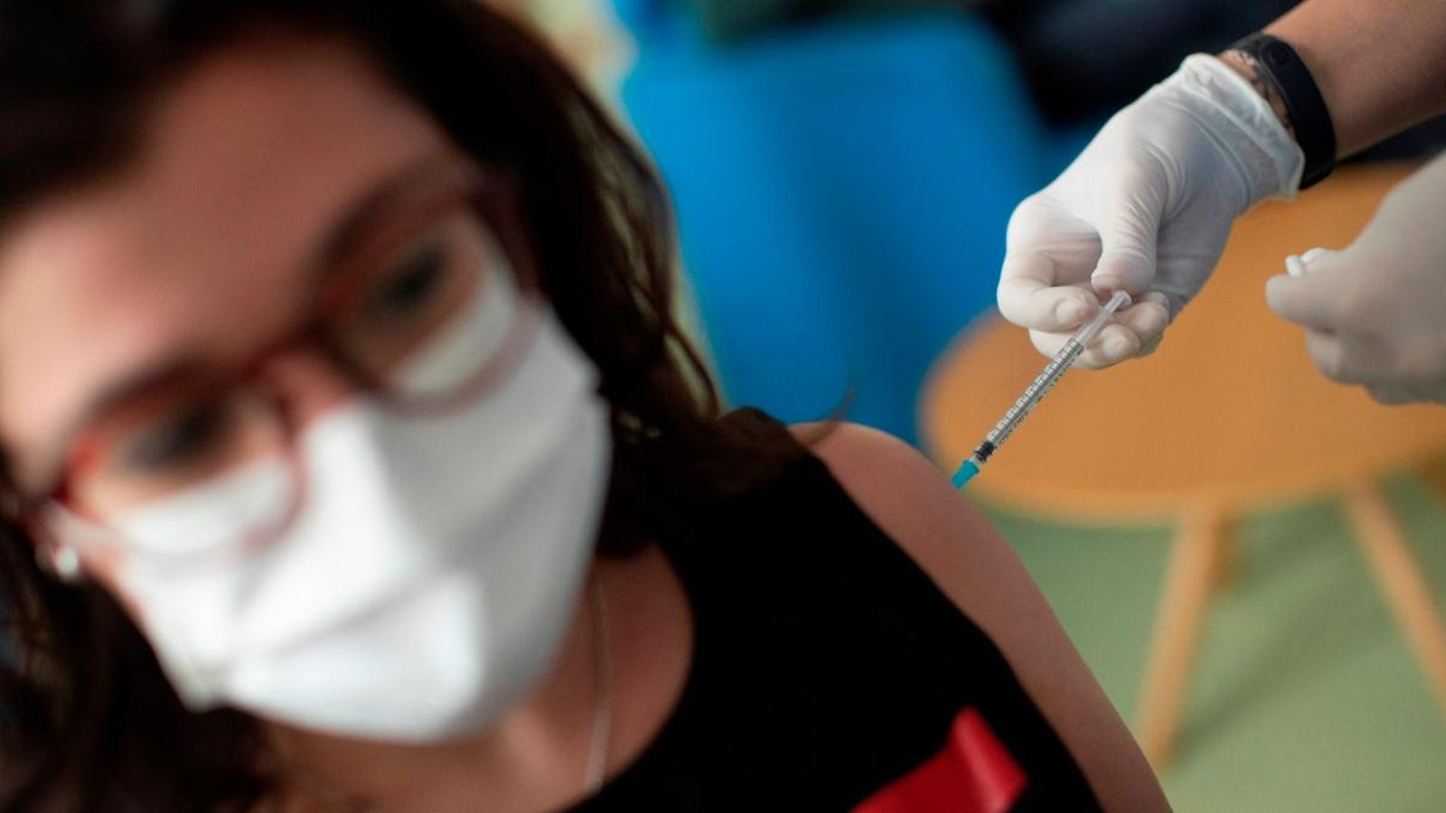 Un sanitari injecta la vacuna contra la Covid-19 a una jove