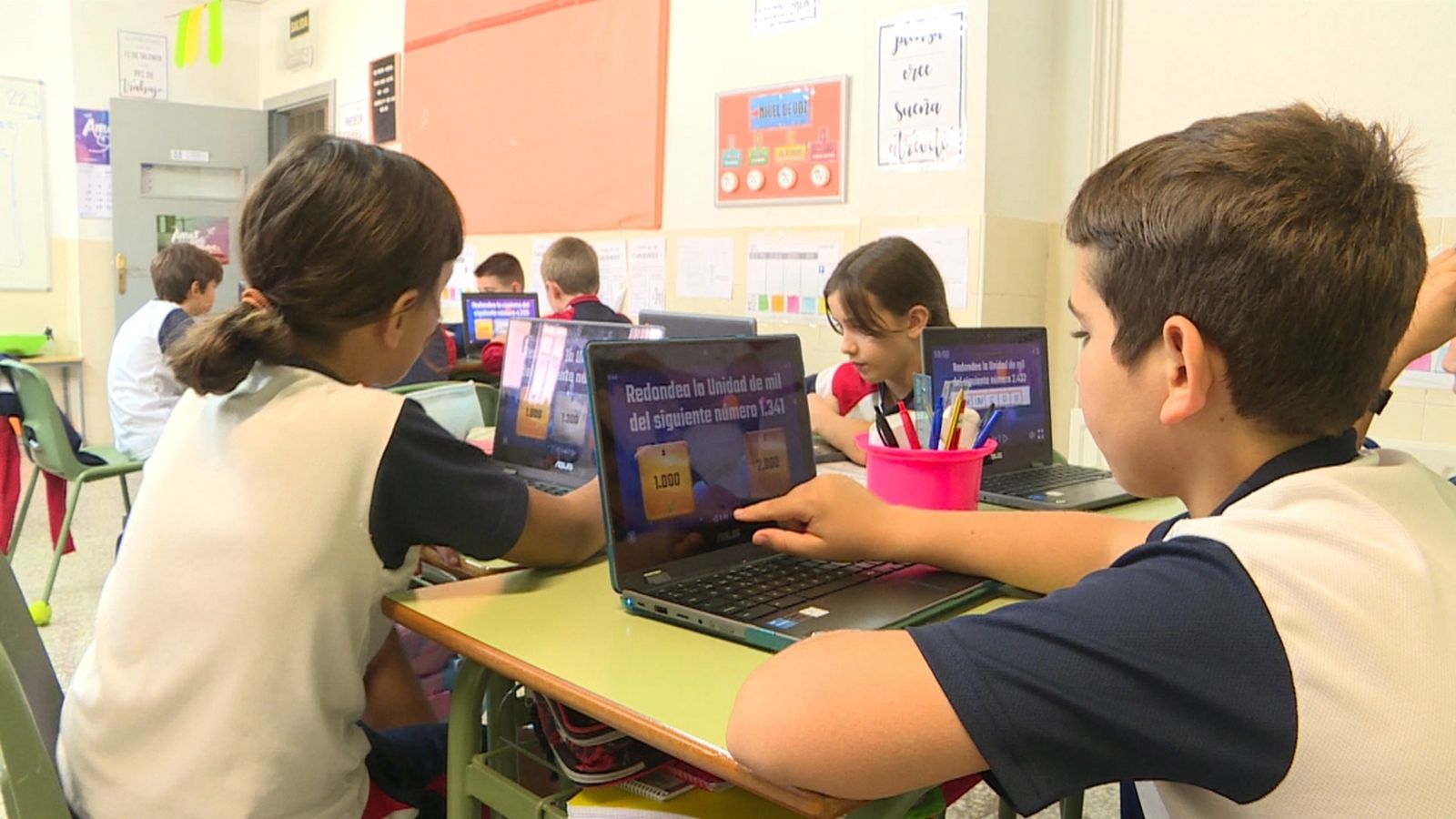 Uns xiquets aprenen els continguts didàctis mentre juguen amb l'aplicació dissenyada pel professor.