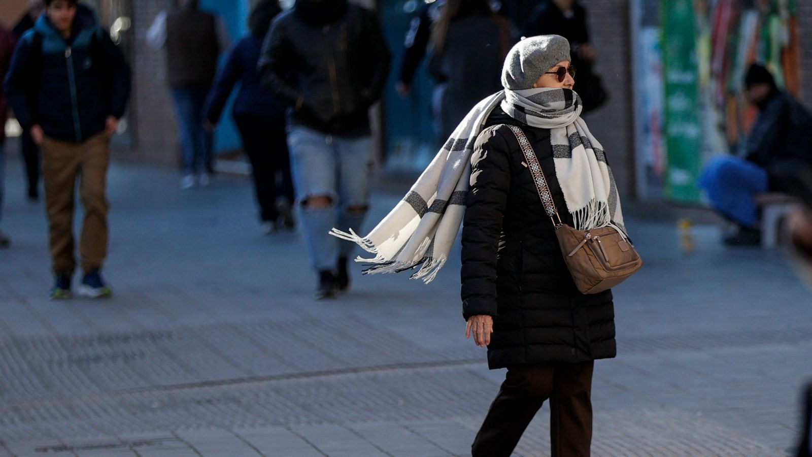 Una persona passeja abrigada per a defensar-se del fred