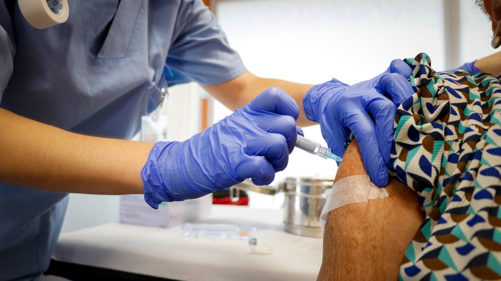 Un sanitari vacuna una anciana