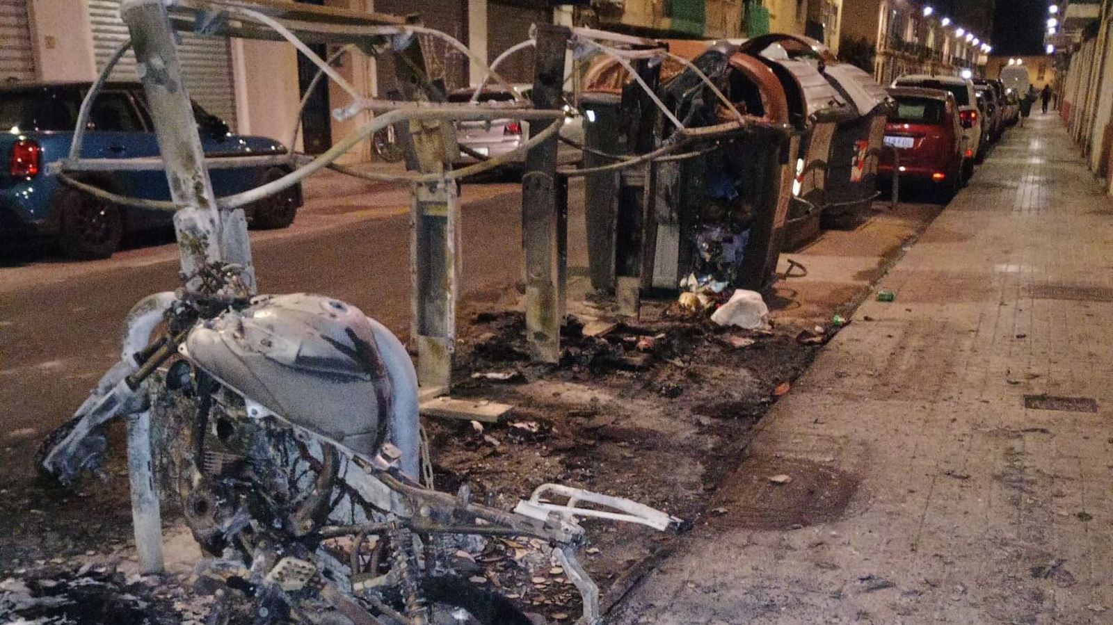 Estat en què han quedat alguns dels contenidors i la moto cremada al carrer Sant Joan Bosco de València