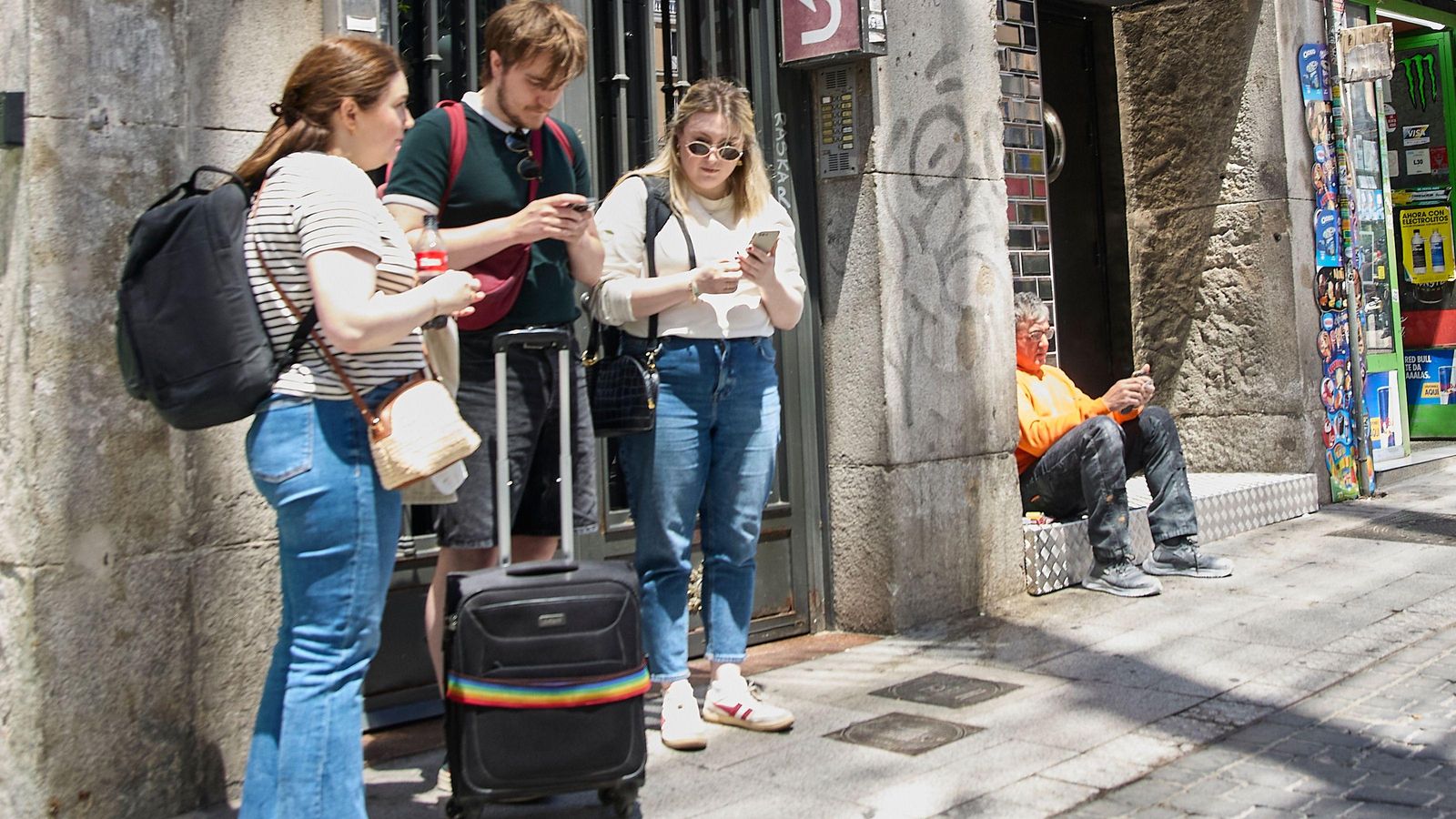 Joves amb maletes en l'exterior d'un pis turistico