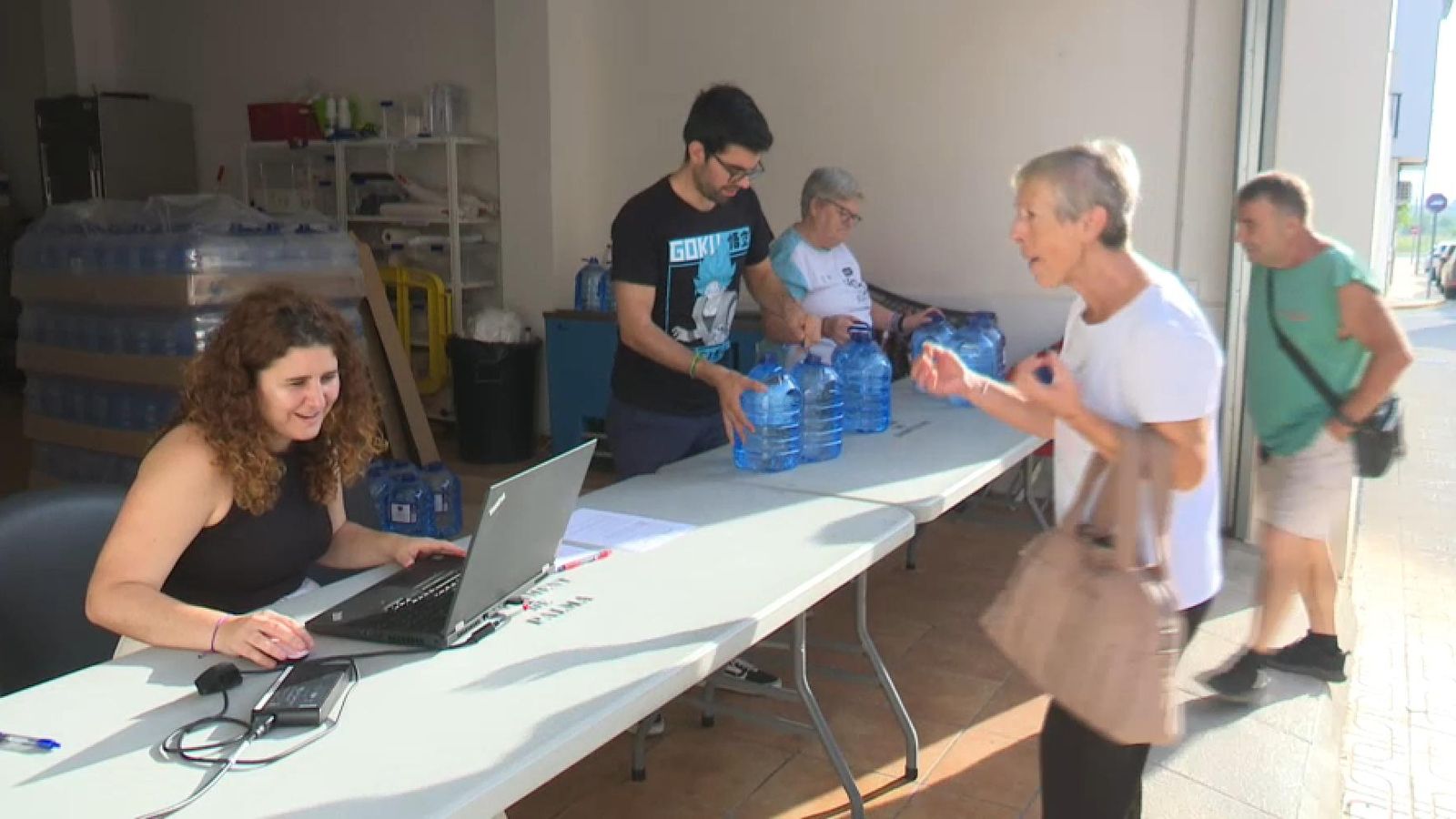 Diversos veins s'acosten fins al punt de repartiment de garrafes d'aigua habilitat per l'Ajuntament de Palma de Gandia