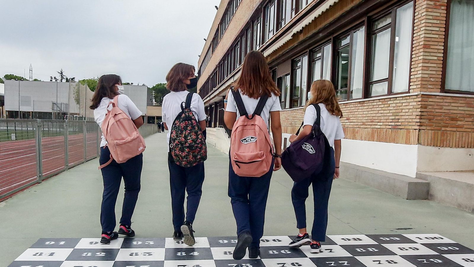 Quatre xiquetes adolescents es dirigeixen a l'entrada d'una escola
