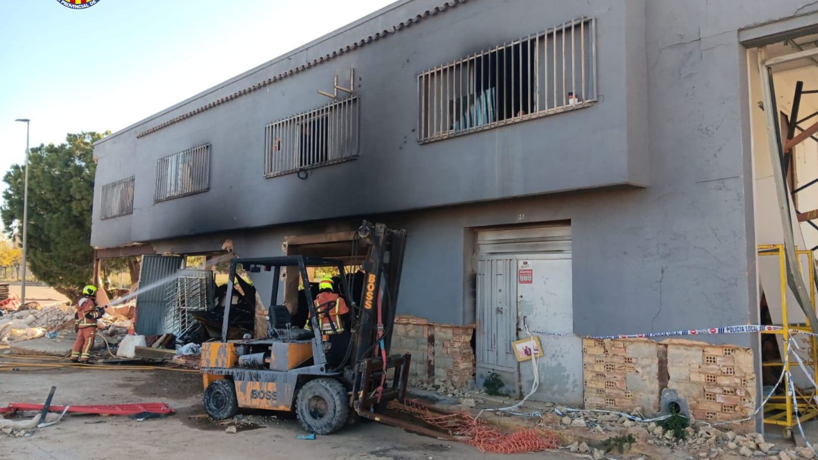 Bombers treballen en l'extinció del foc originat en una nau afectada per la dana a Torrent