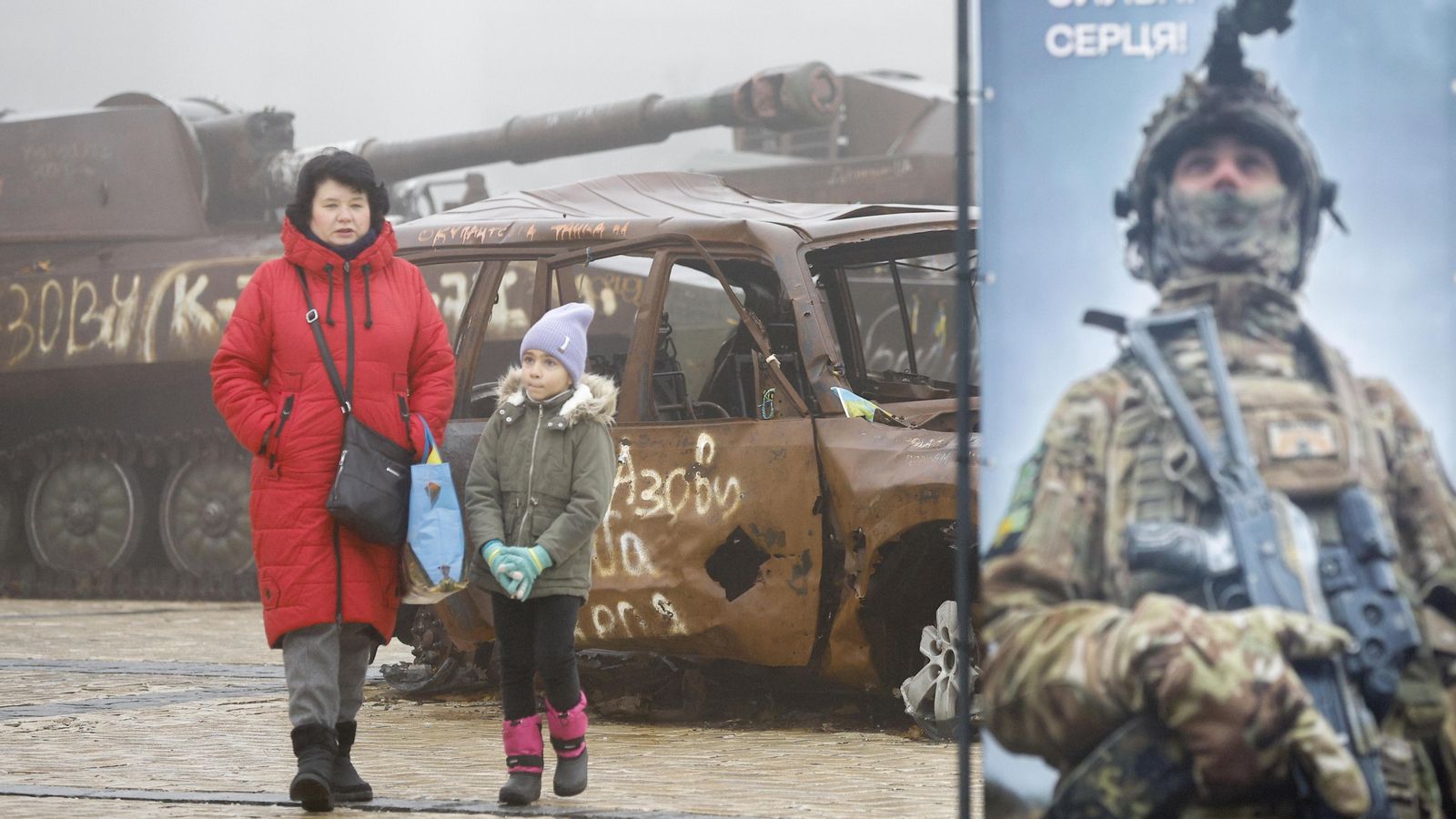 Una dona i una xiqueta caminen al costat de maquinària militar russa que s'exhibeix prop de la catedral de San Mykhailivsky en el centre de Kíev, Ucraïna,