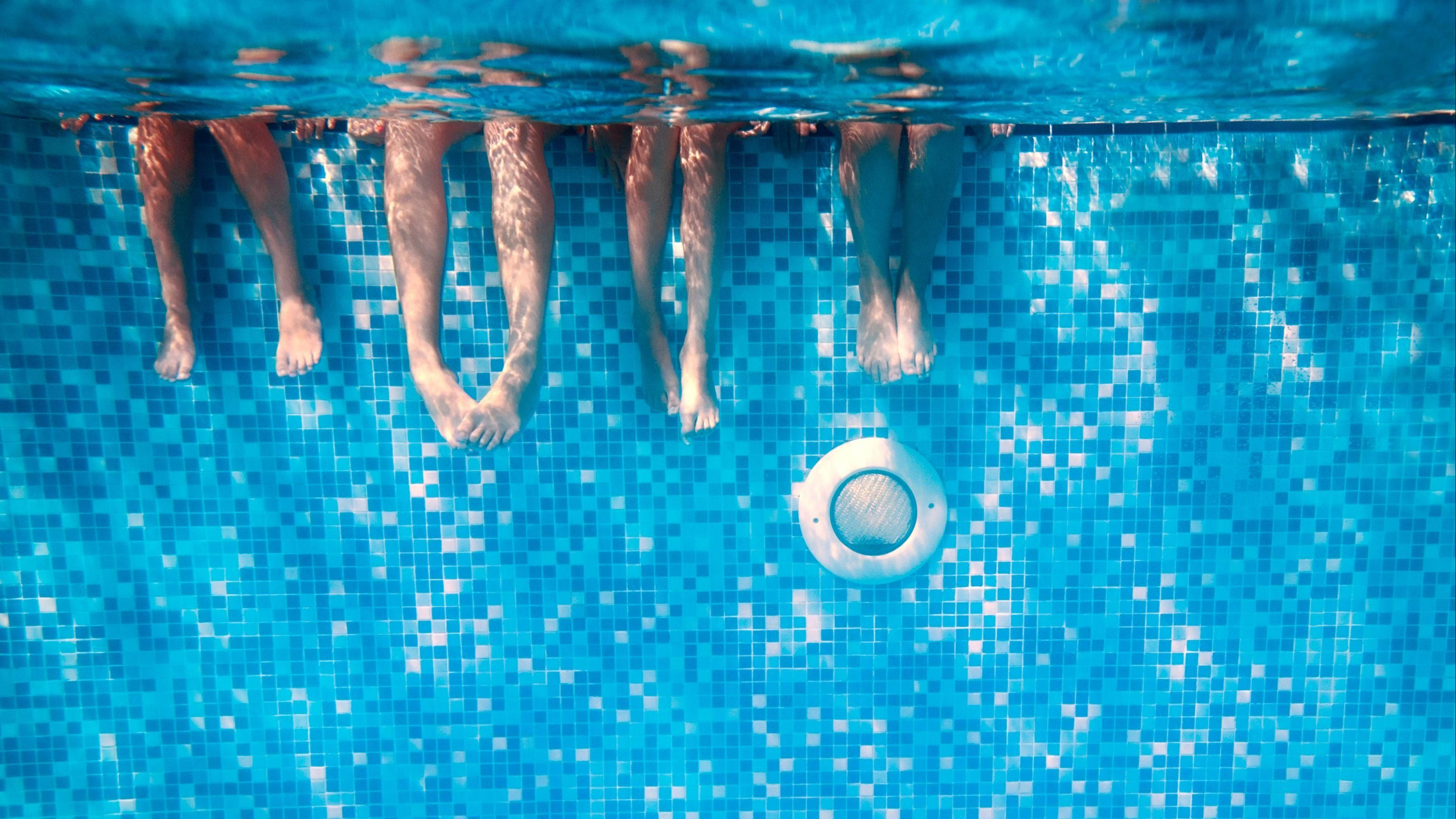 Un grup de persones es refresquen en una piscina Un grup de persones es refresquen en una piscina