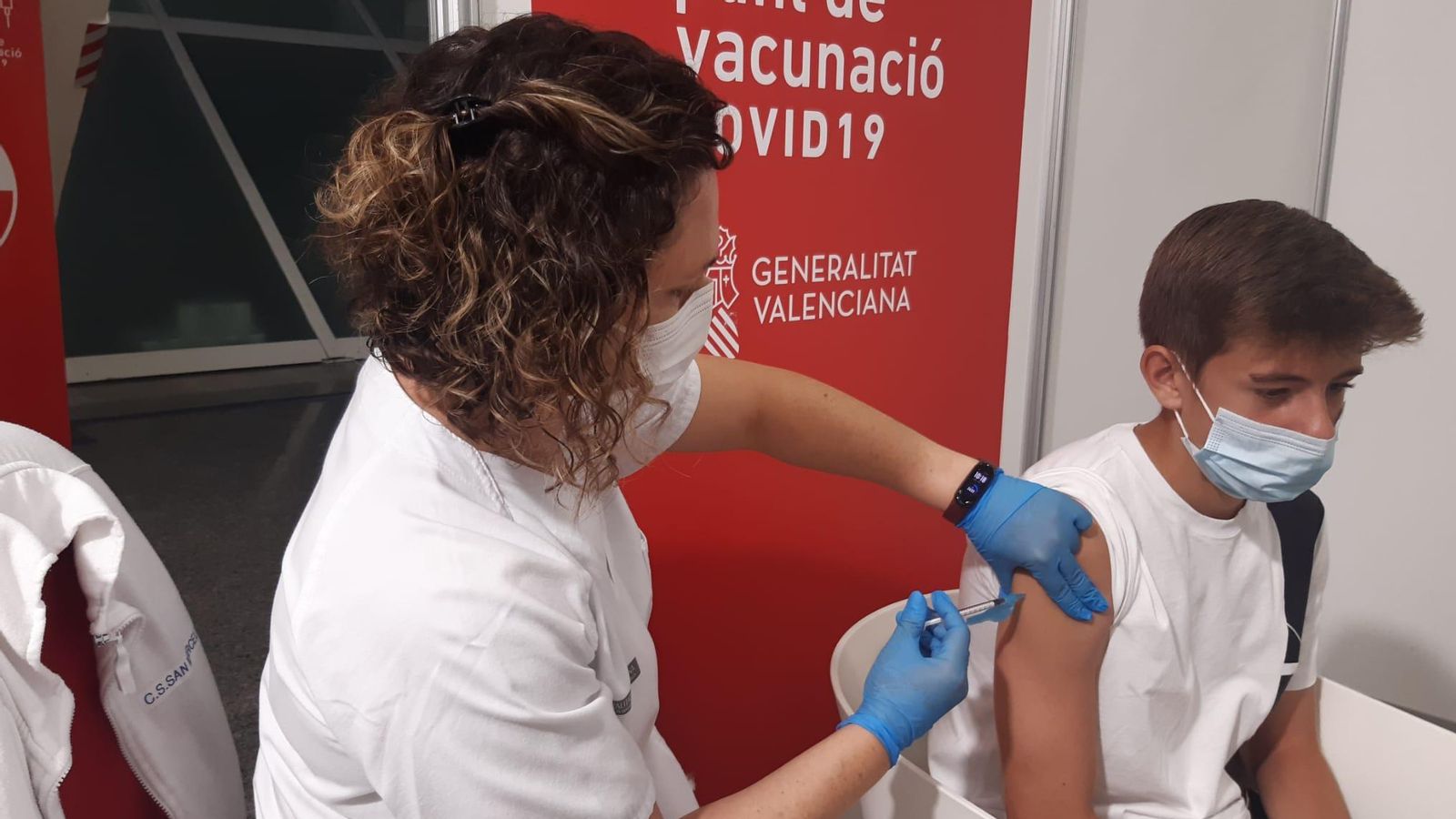 Una sanitària vacuna un adolescent en la Ciutat de les Arts i les Ciències de València