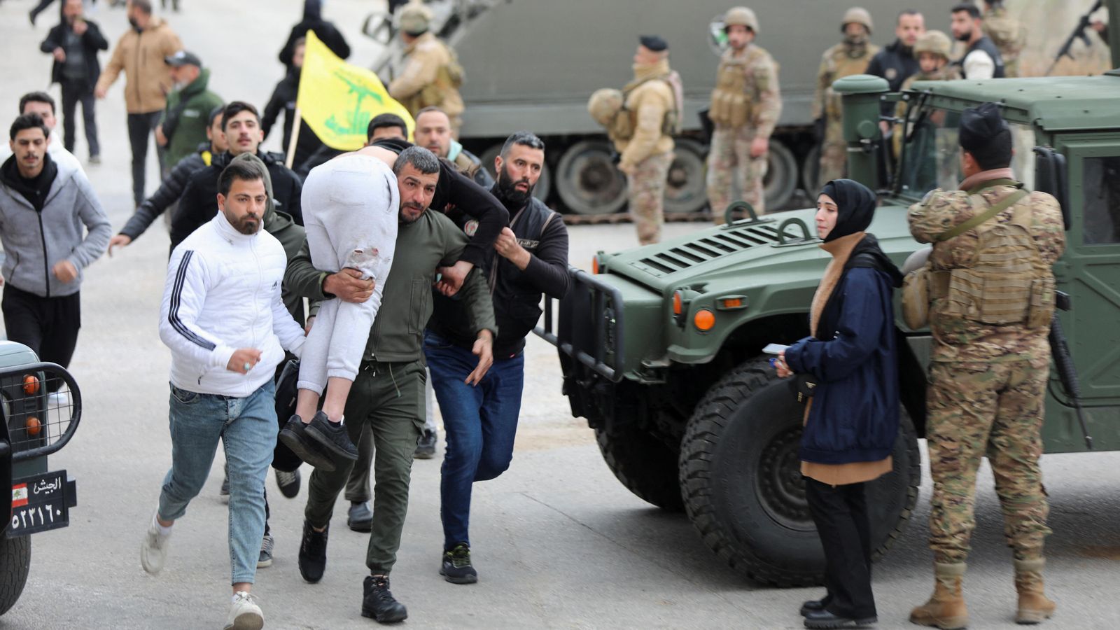Un home carrega una persona ferida en un poble del sud del Líban, on les forces israelianes continuen presents este diumenge