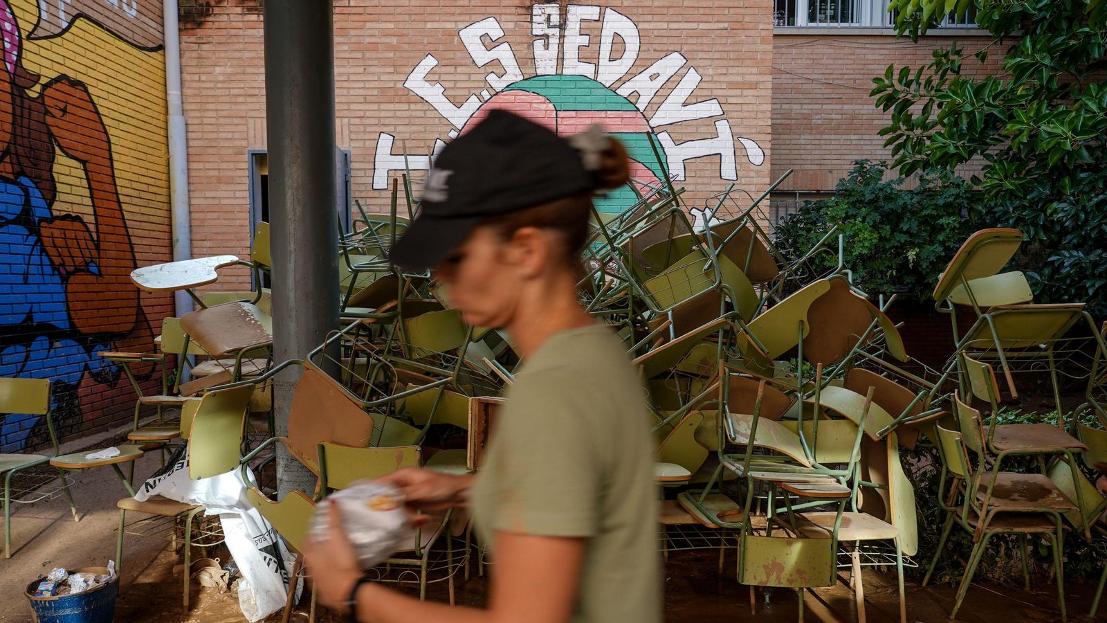 Una dona passa per davant del pati d'un institut de Sedaví, negat per les riuades d'octubre