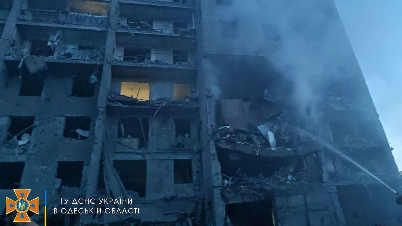 Els bombers tractes de sufocar l'incendi posterior a l'impacte del míssil en un dels edifics danyays