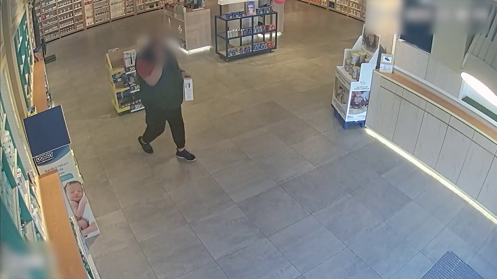 Imatge d'una de les càmeres que va enregistrar un dels presumptes lladres emportant-se articles d'una farmàcia