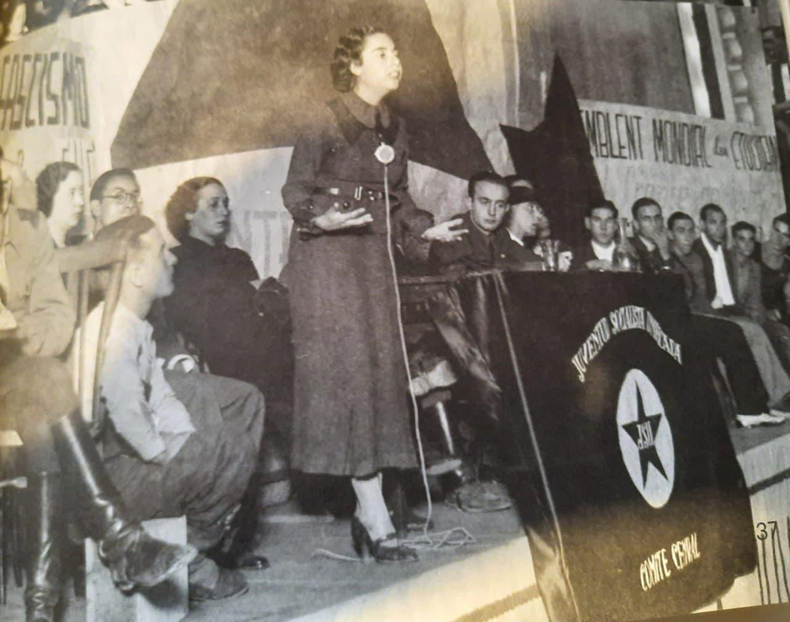 Alejandra Soler intervenint en un acte en el cine Tyris de València, en 1936. En la taula, Ricardo Muñoz Suay.