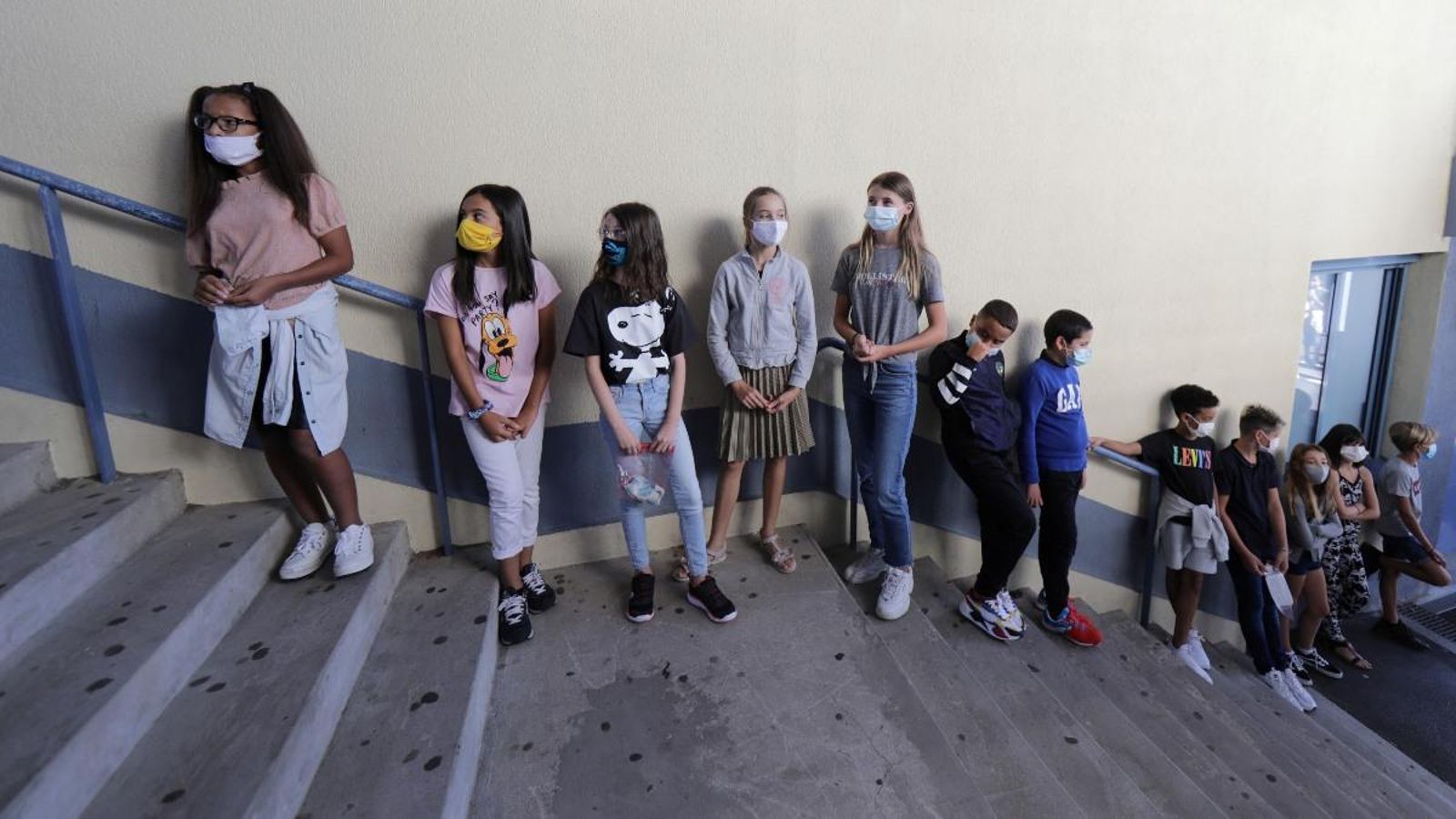 Un grup d'alumnes de secundària amb mascareta fa cua per a accedir a l'aula en el primer dia de classe a Niça