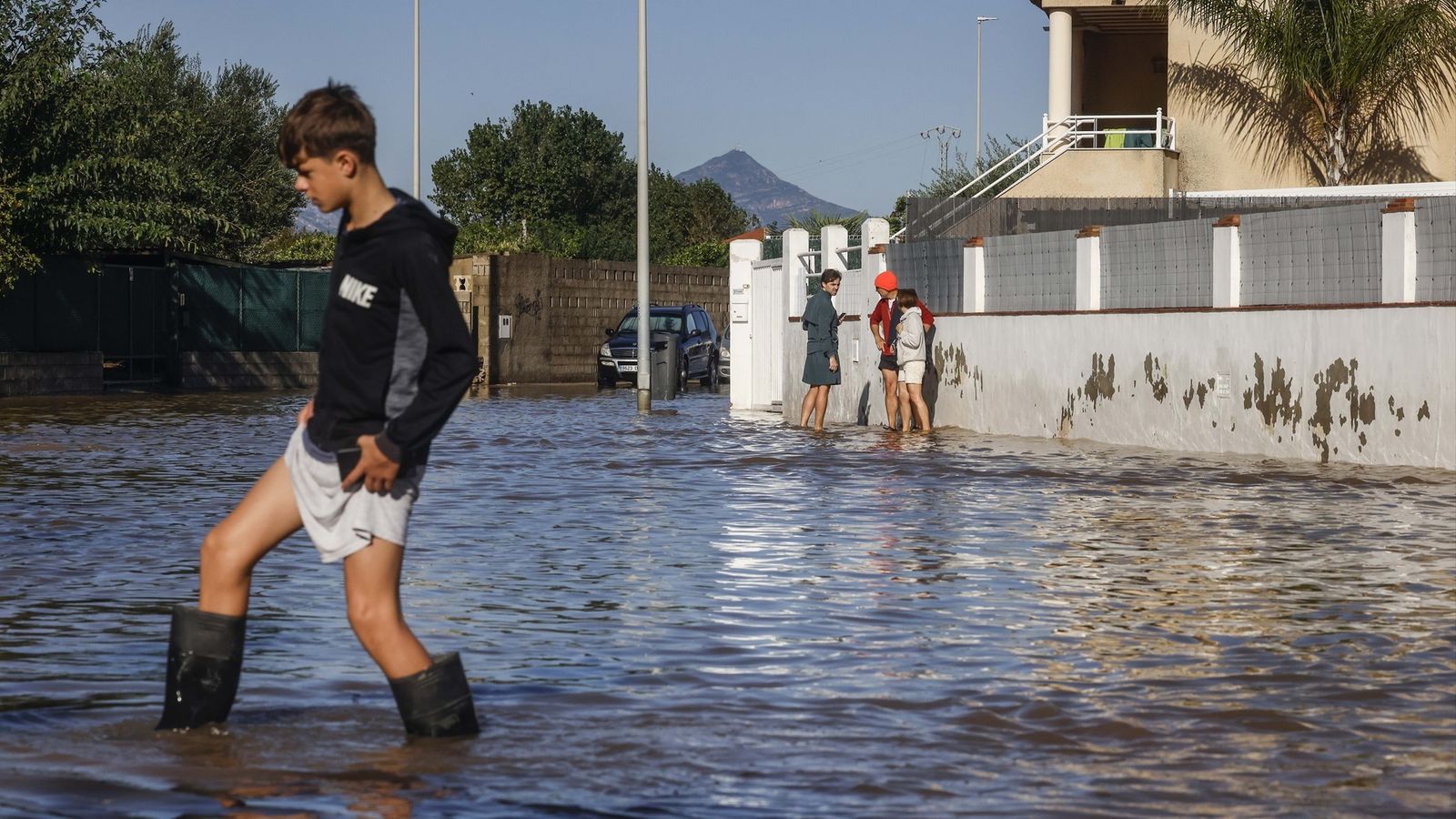 Un xiquet camina per un carrer negat a Oliva després del pas de la dana Adam