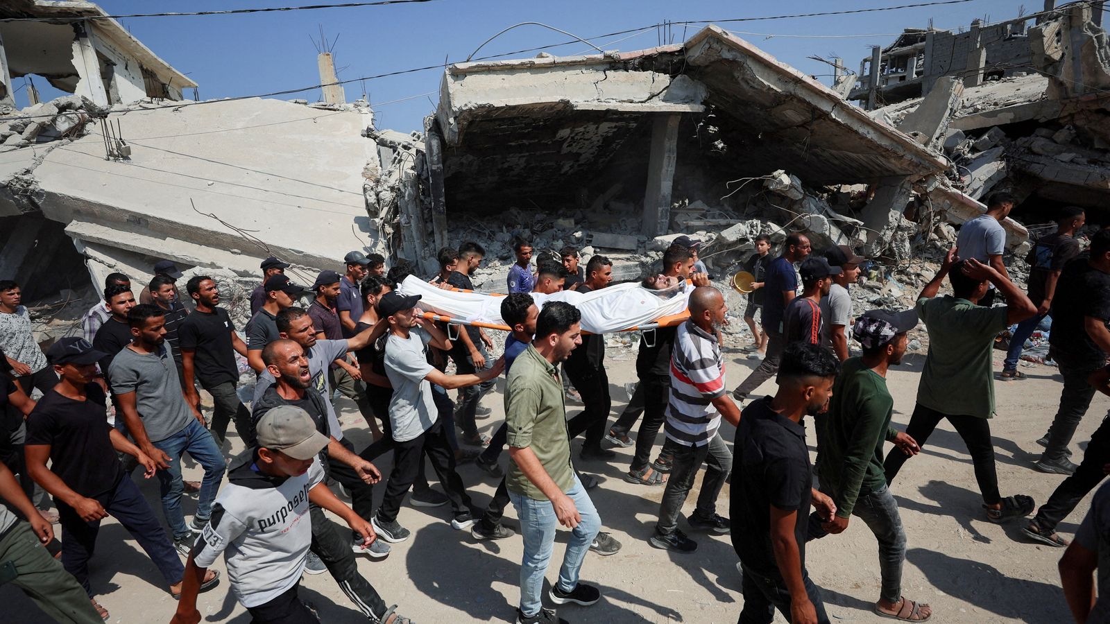Un grup de palestins trasllada el cadàver d'un home assassinat en un atac a la ciutat de Gaza el 16 de juliol