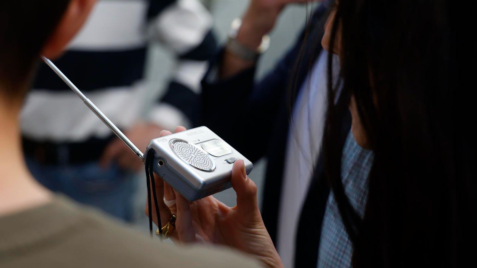 Una dona segueix la última hora de l'apagada amb un transistor