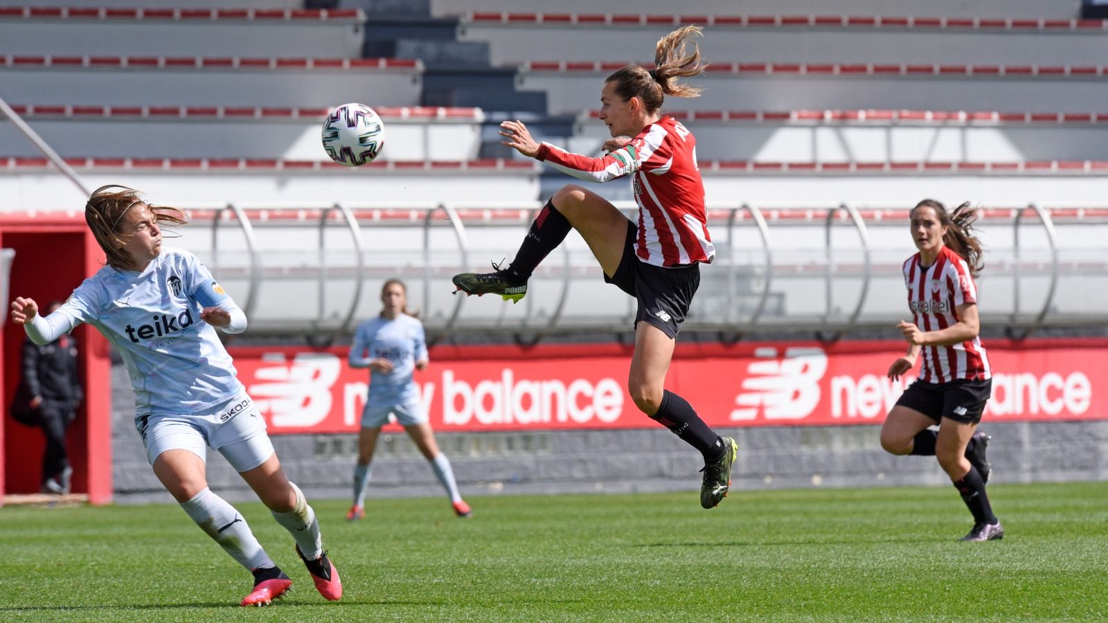 Una jugadora del València i una altra de l'Athletic Club disputen un baló dividit