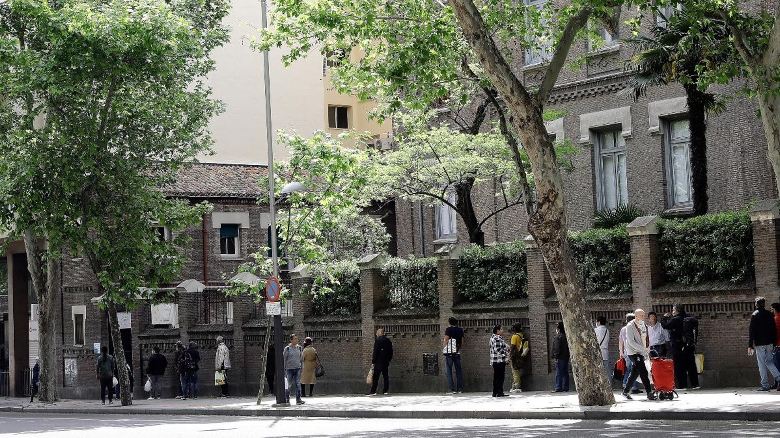Persones fent cua a la porta d'un menjador social en Madrid