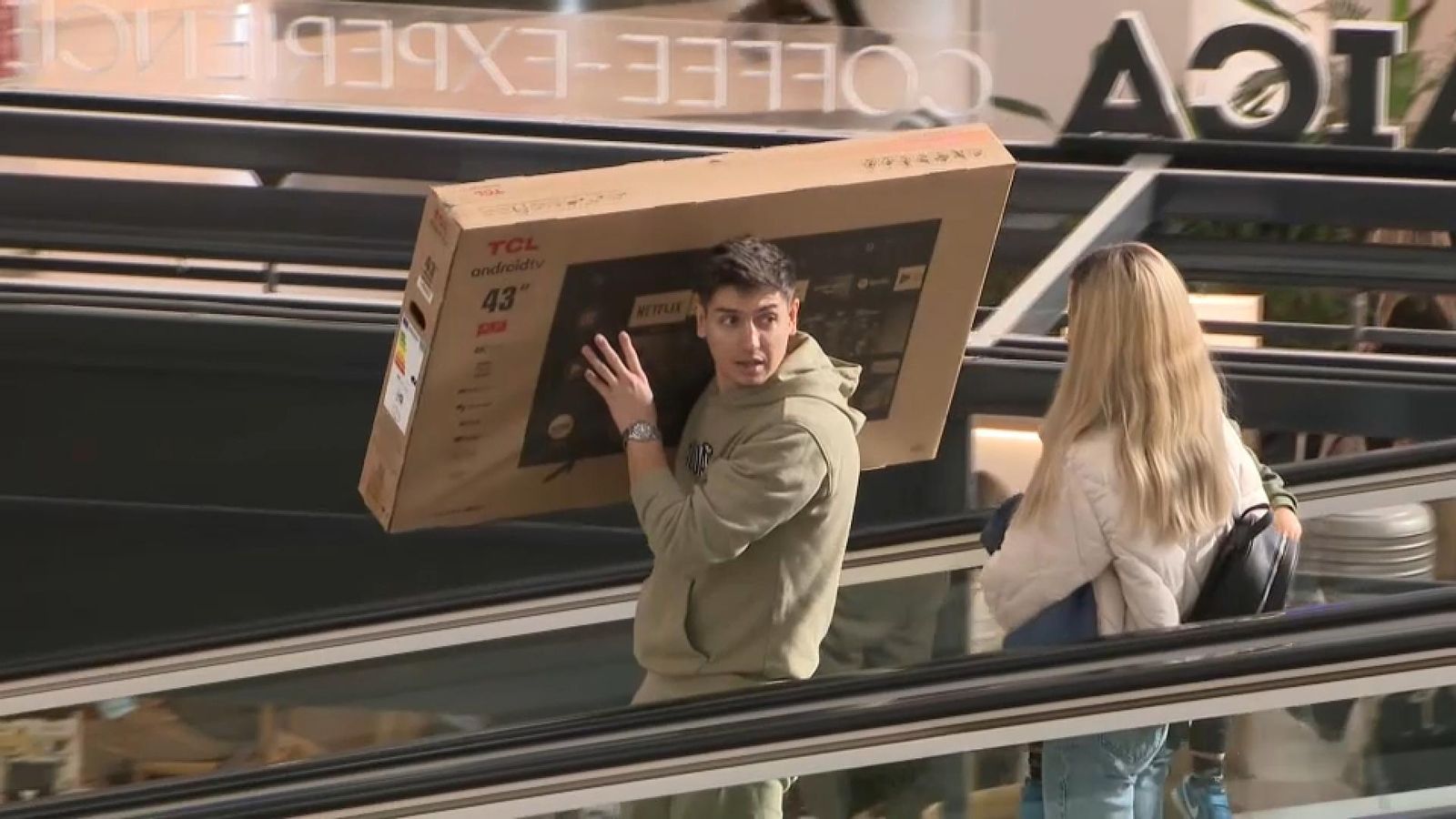 Un home carrega un televisor recent comprat en un centre comercial valencià, en una imatge d'arxiu