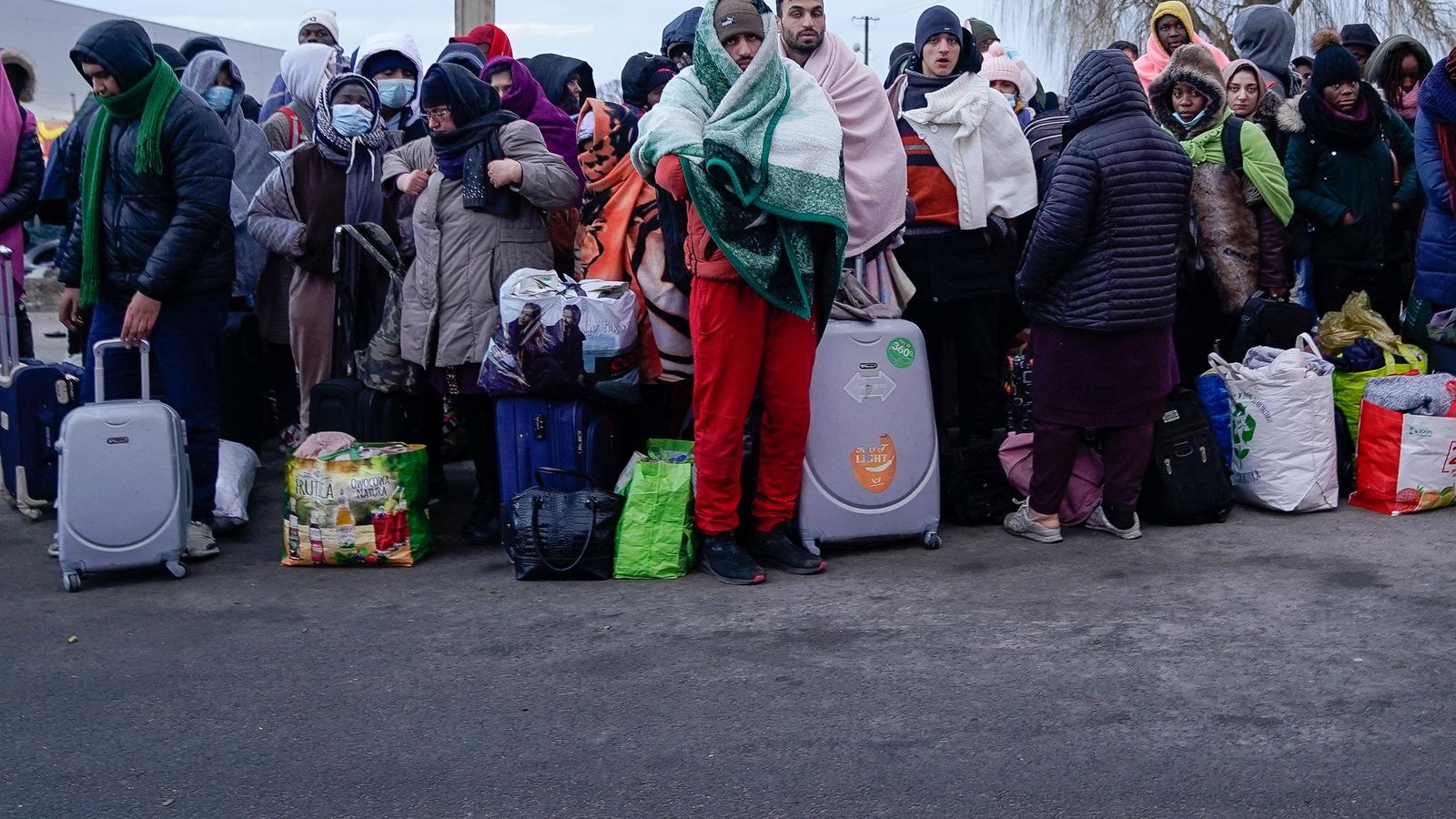 Persones refugiades d'Ucraïna esperen un autobús per a ser conduïts a un centre d'acollida a Polònia