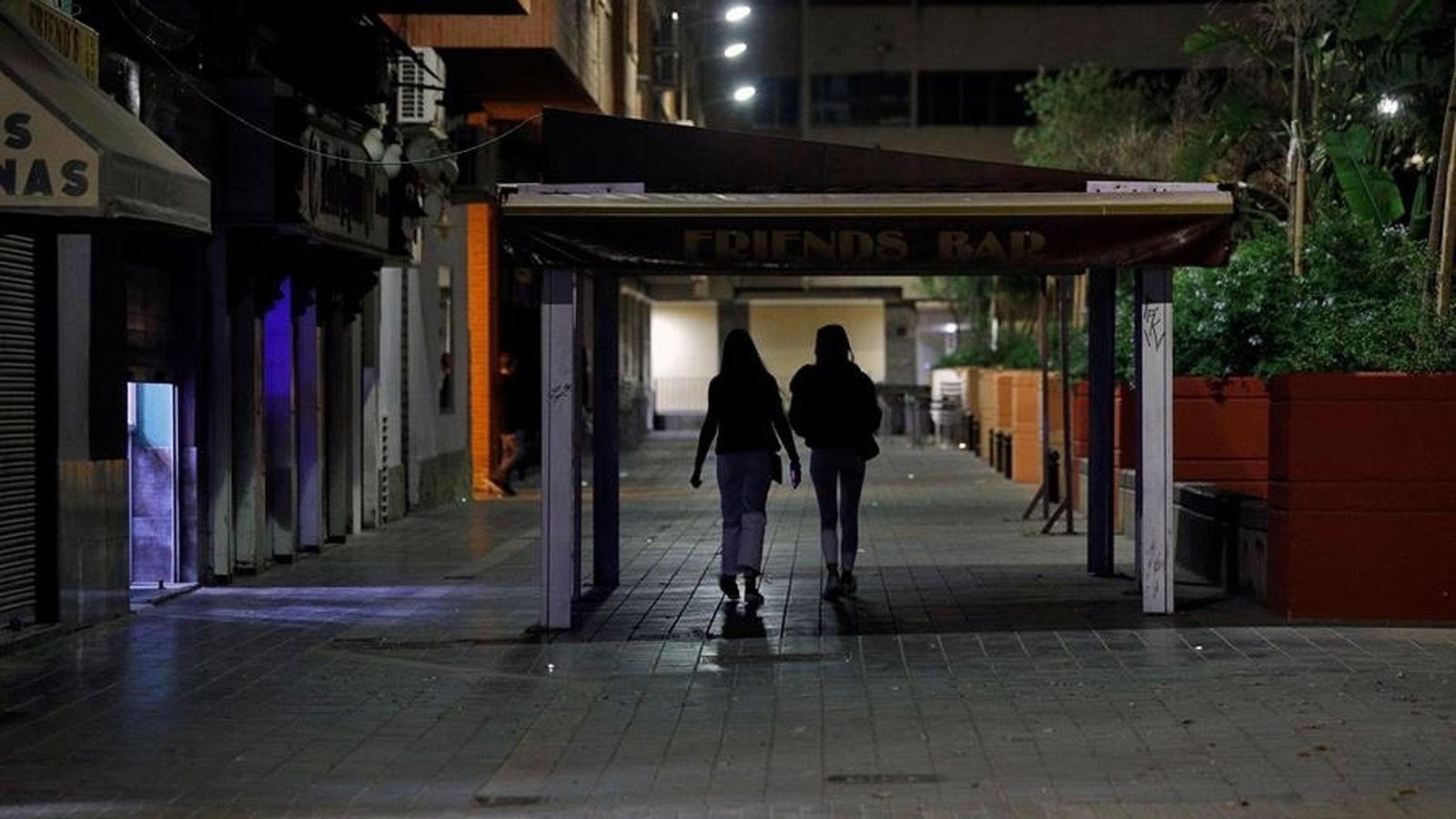 Dos joves pels carrers de València, poc abans de l'entrada en vigor del toc de queda