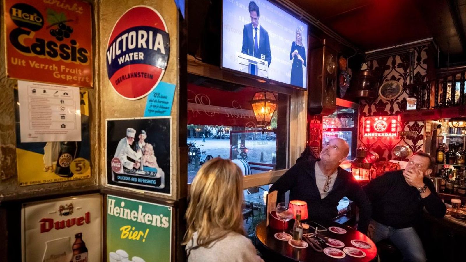 Clients del café Marcella, a Amsterdam segueixen la conferència sobre les noves mesures pel coronavirus als Països Baixos