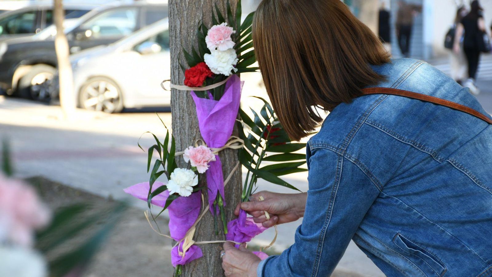 Una veïna deixa flors en un altar improvisat durant una concentració