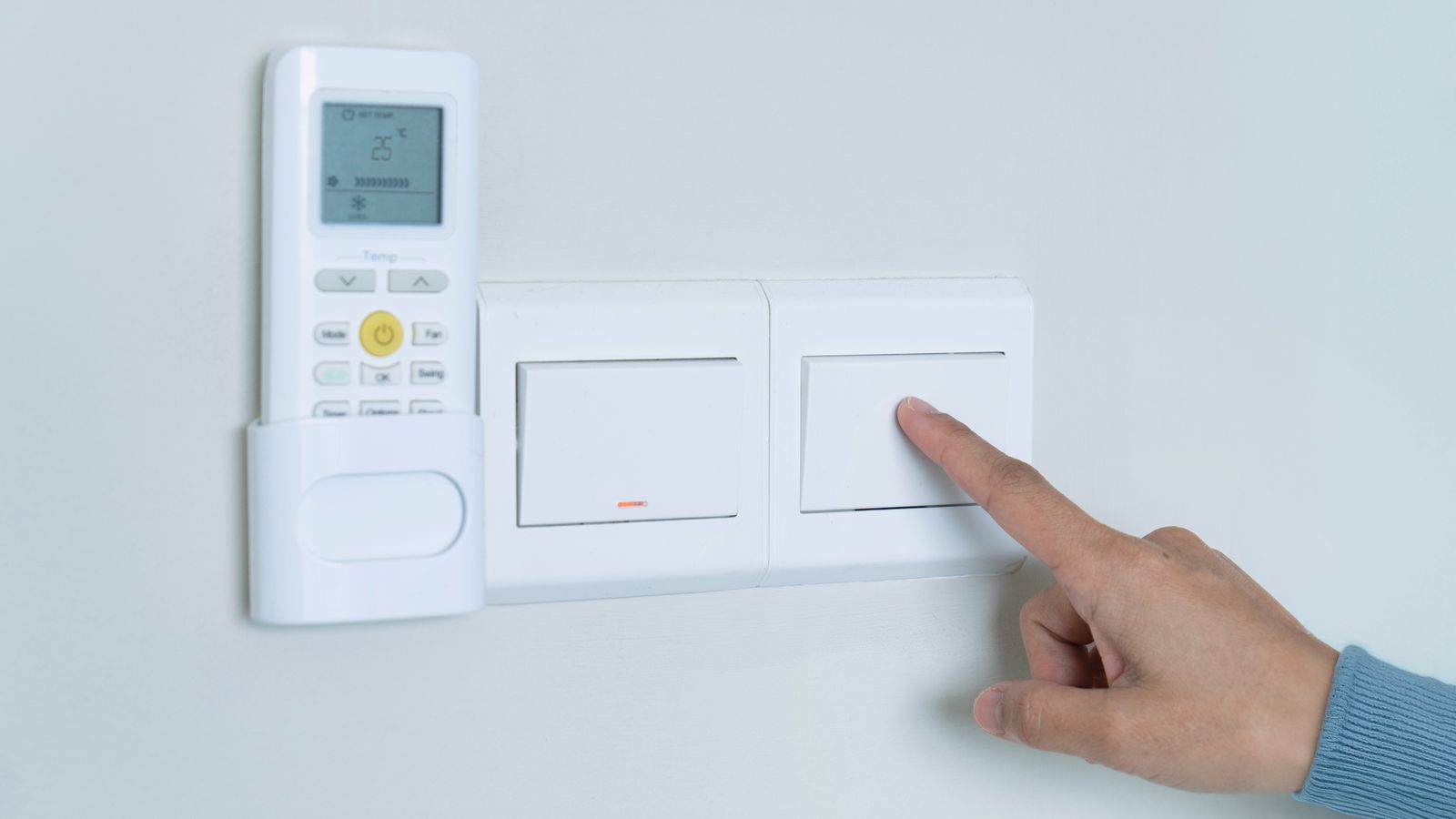 Una persona apaga un interruptor de la llum