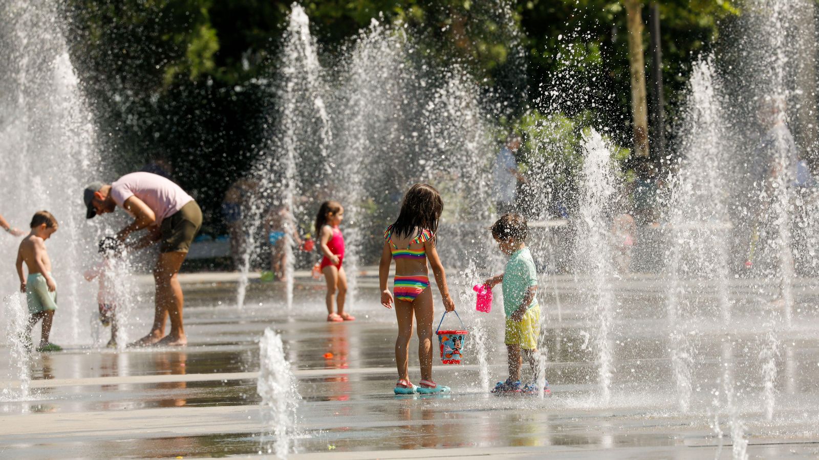 Uns xiquets es refresquen en les fonts del parc Central, a València, davant les altes temperatures