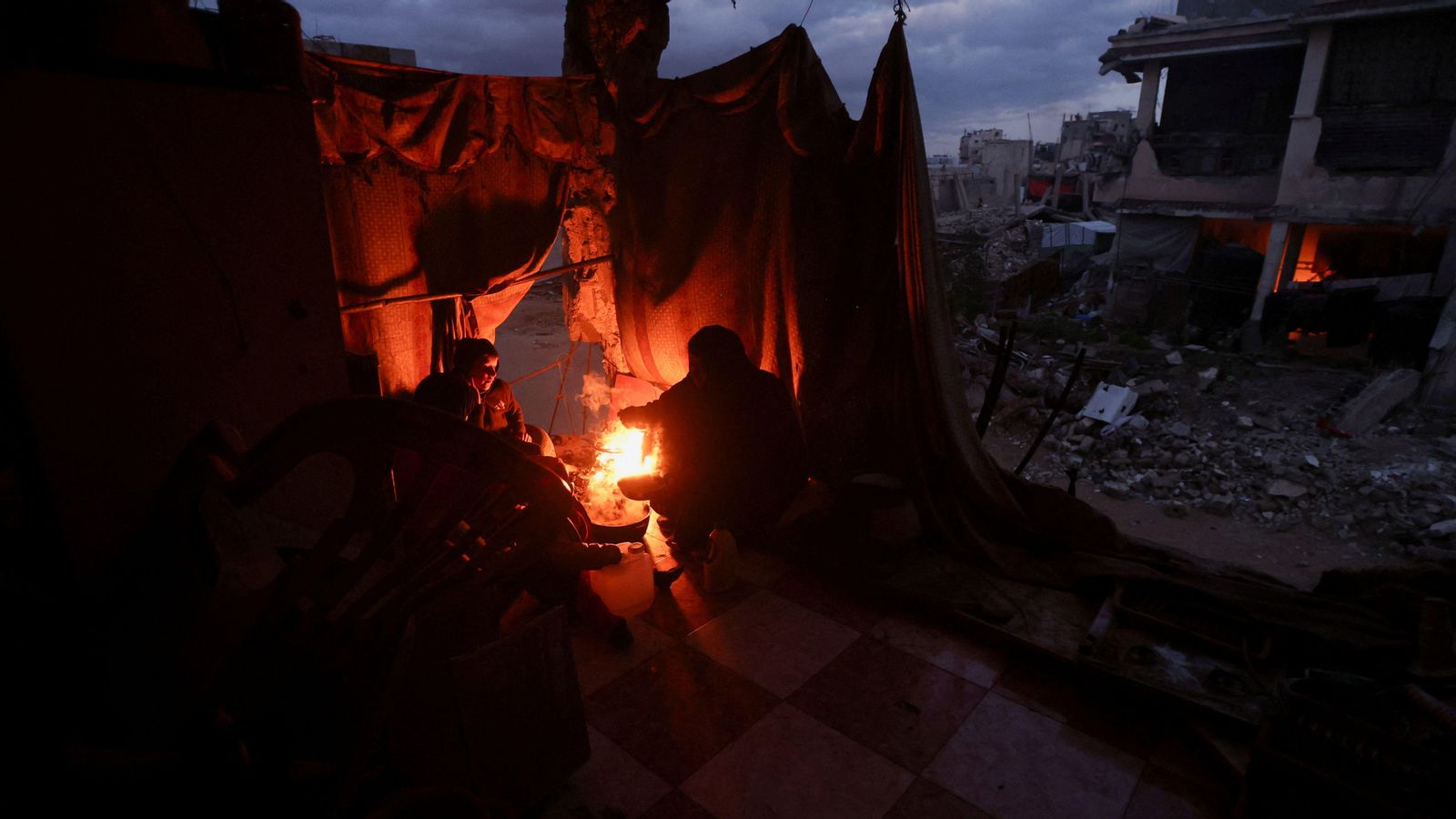 Un grup de palestins encén una foguera per a combatre el fred a Khan Yunis