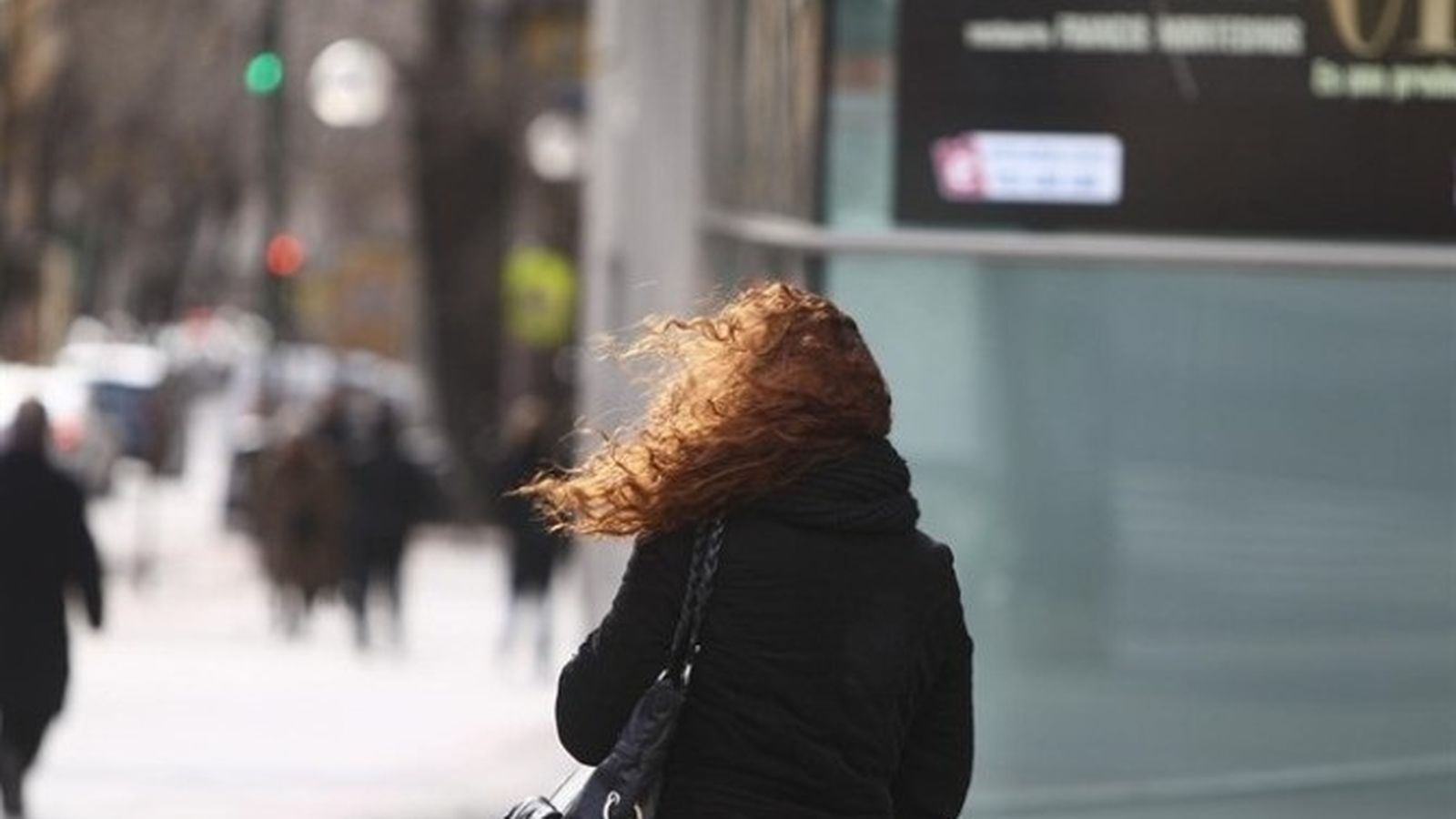 Foto d'arxiu d'una dona afectada per fortes ratxes de vent