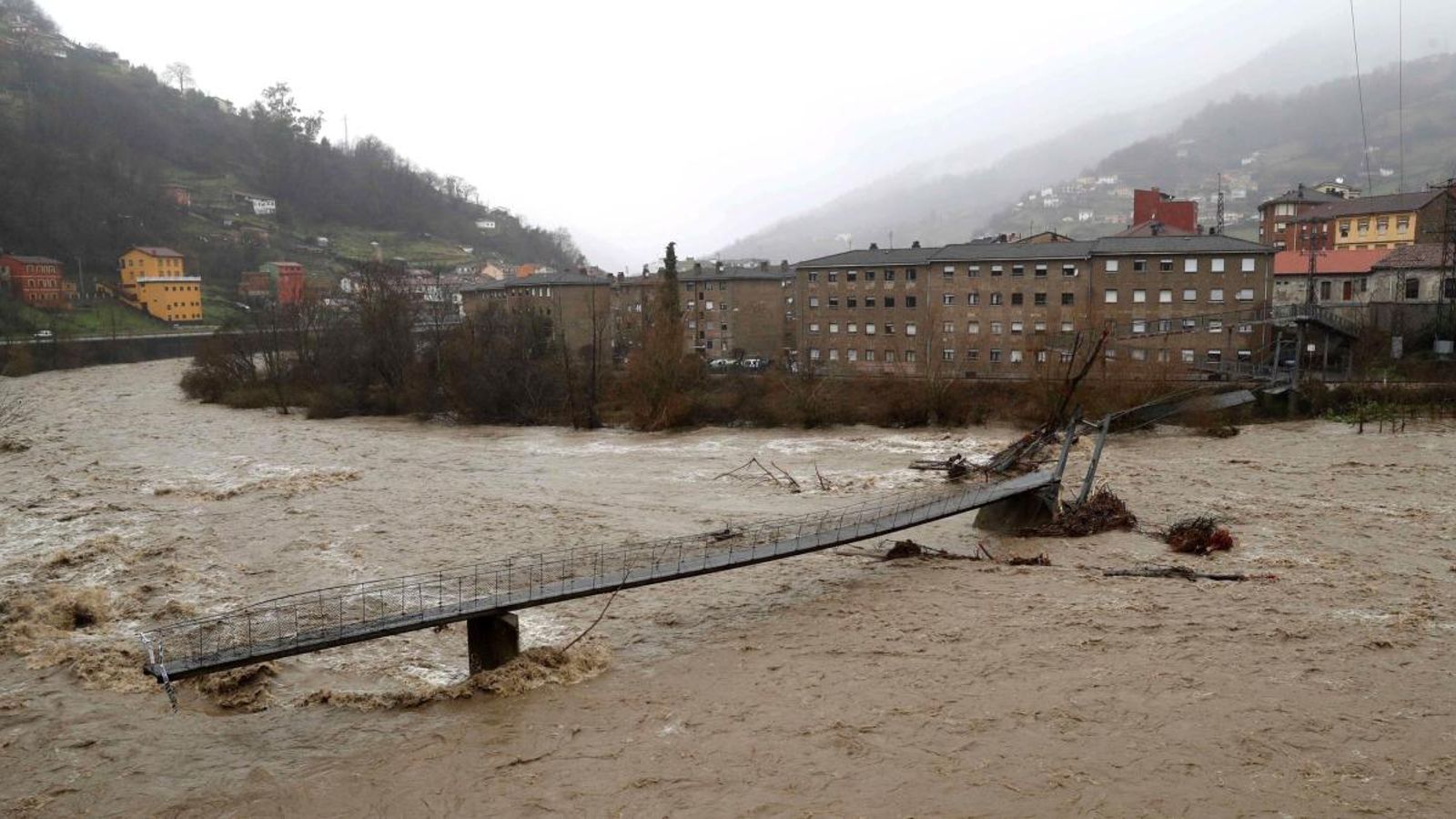Aspecte que presenta una passarel·la per als vianants sobre el riu Aller a causa del temporal de pluges a Astúries. José Luis Cereijido (Efe)