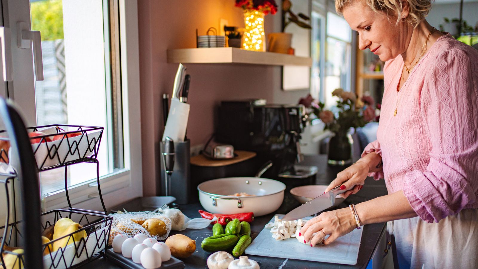 Dona que talla aliments per a la preparació d'un menjar sa, imatge d'arxiu