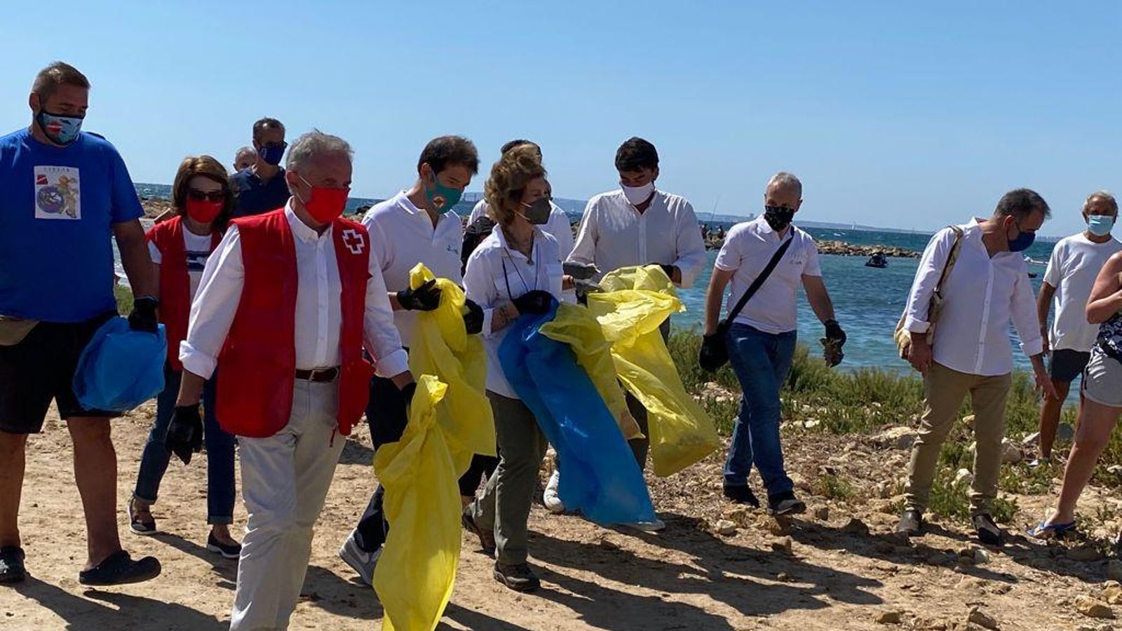 La reina emèrita amb un grup de voluntaris, a la platja de l'Almadrava d’Alacant