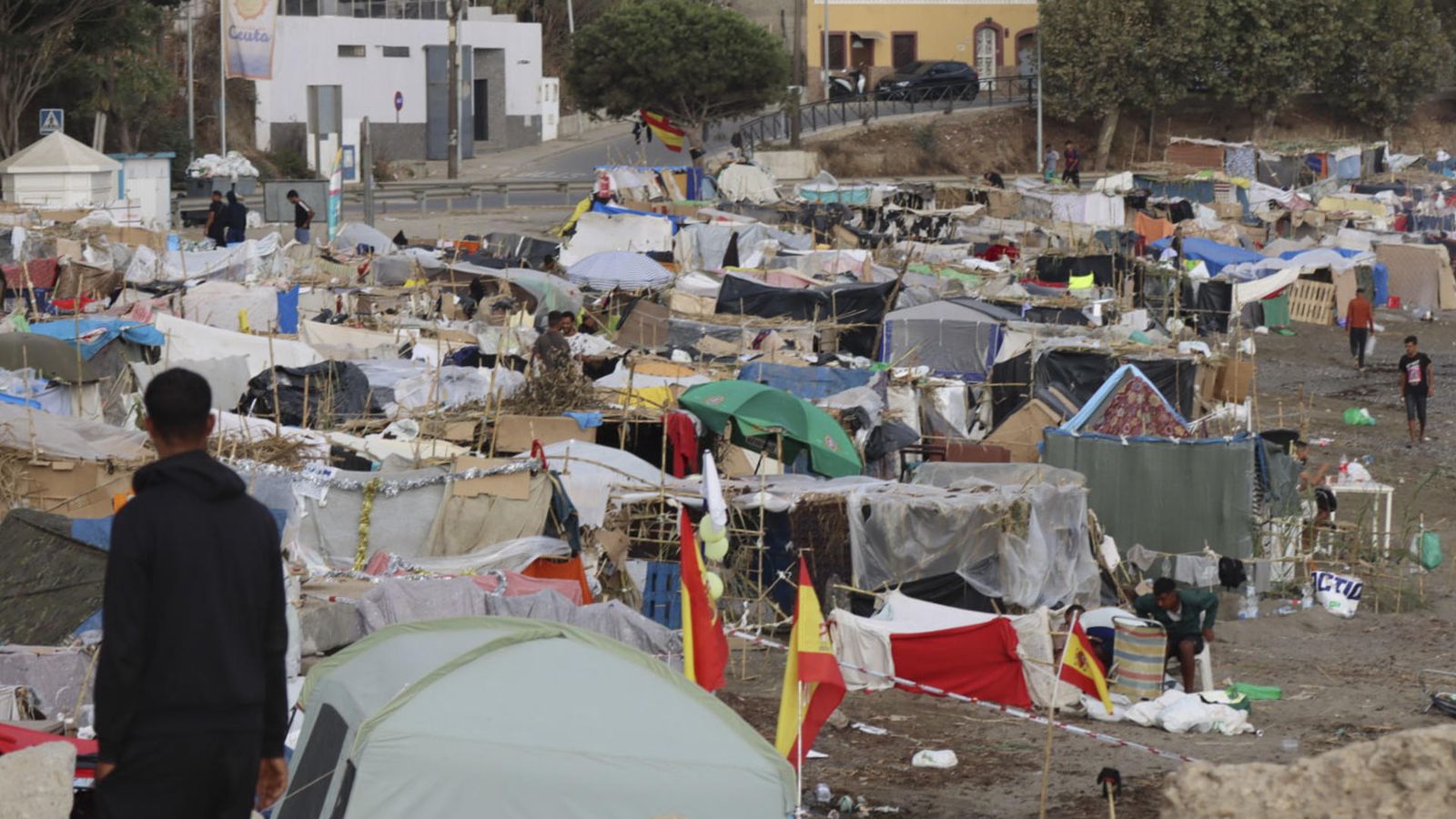 Vista de les tendes de campanya i les construccions improvisades pels migrants assentats a la platja del Trampolín, este diumenge a Ceuta.