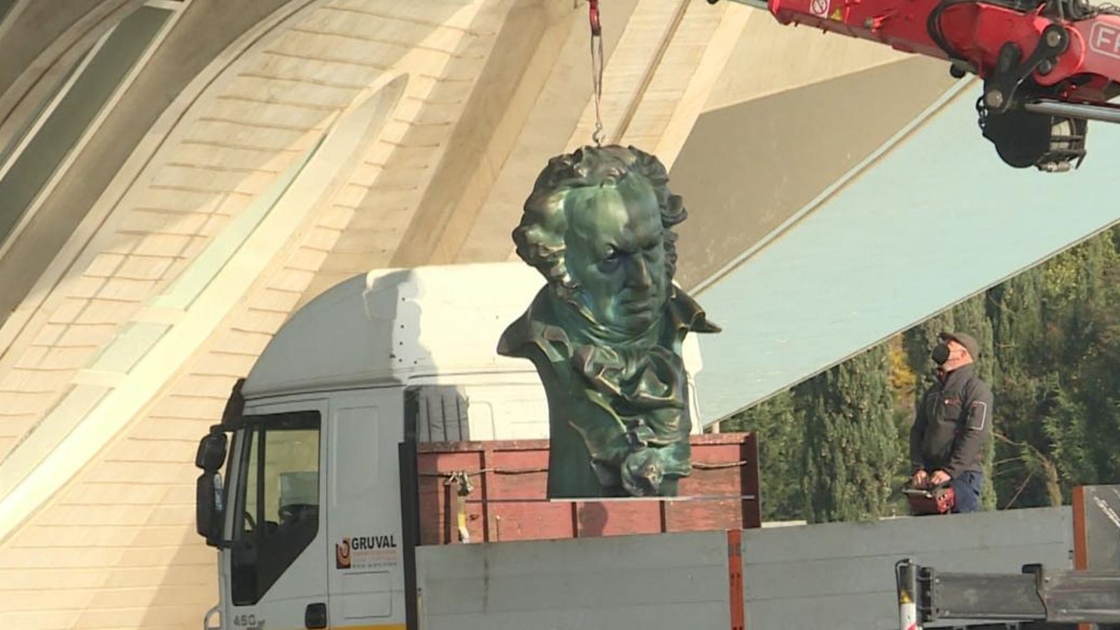 Els operaris col·loquen una figura dels Goya enfront del Palau de les Arts de València