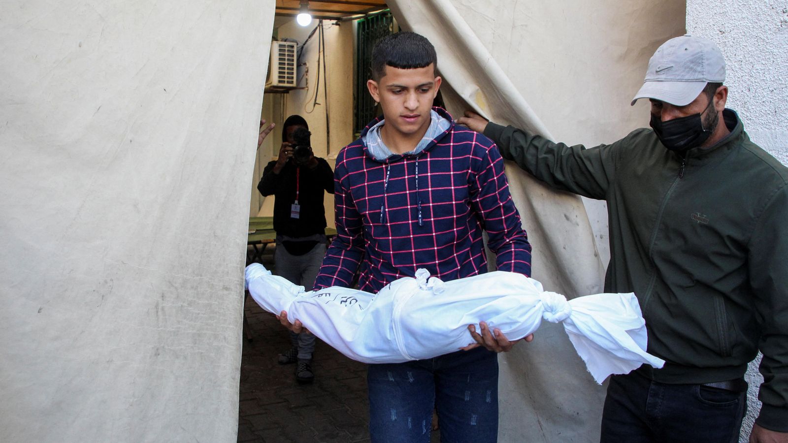 Un home carrega el cadàver d'un xiquet mort en un dels últims bombardejos d'Israel sobre Rafah