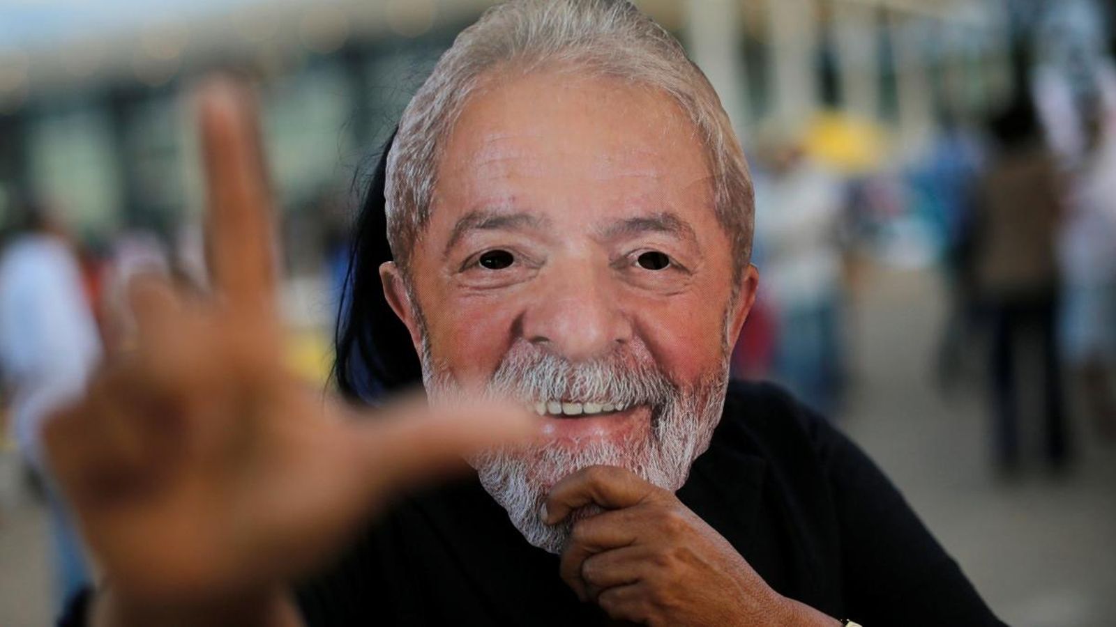 Un manifestant favorable a l'alliberament de l'expresident Lula da Silva amb una careta del mandatari