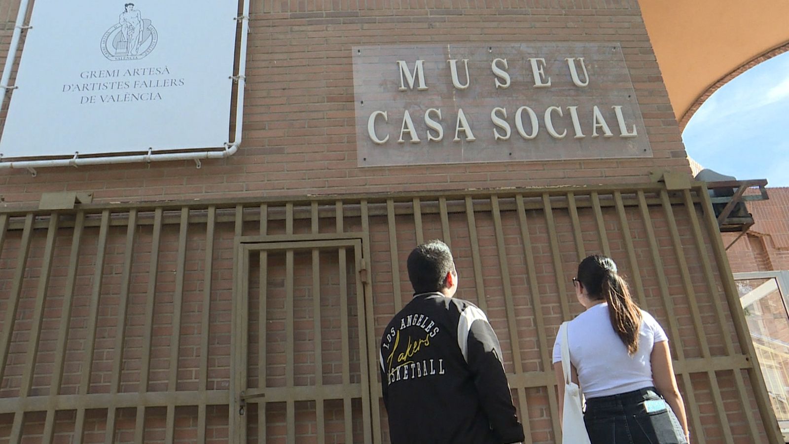 Dos joves davant el gremi d'artesania d'artistes fallers de València