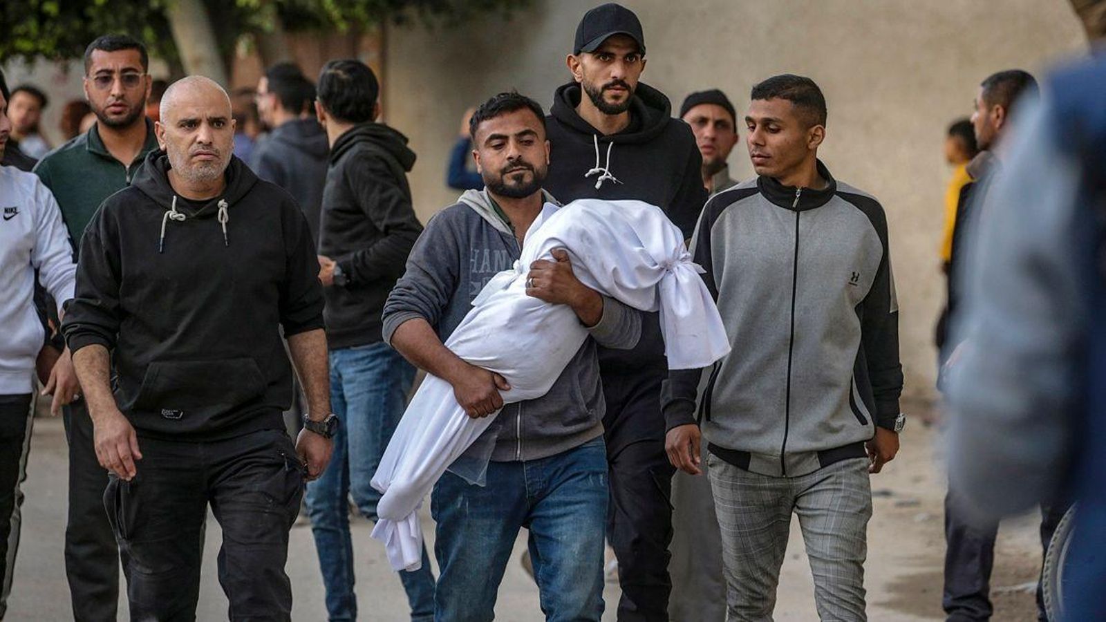 Un palestí carrega el cadàver d'un dels xiquets assassinats en l'escola