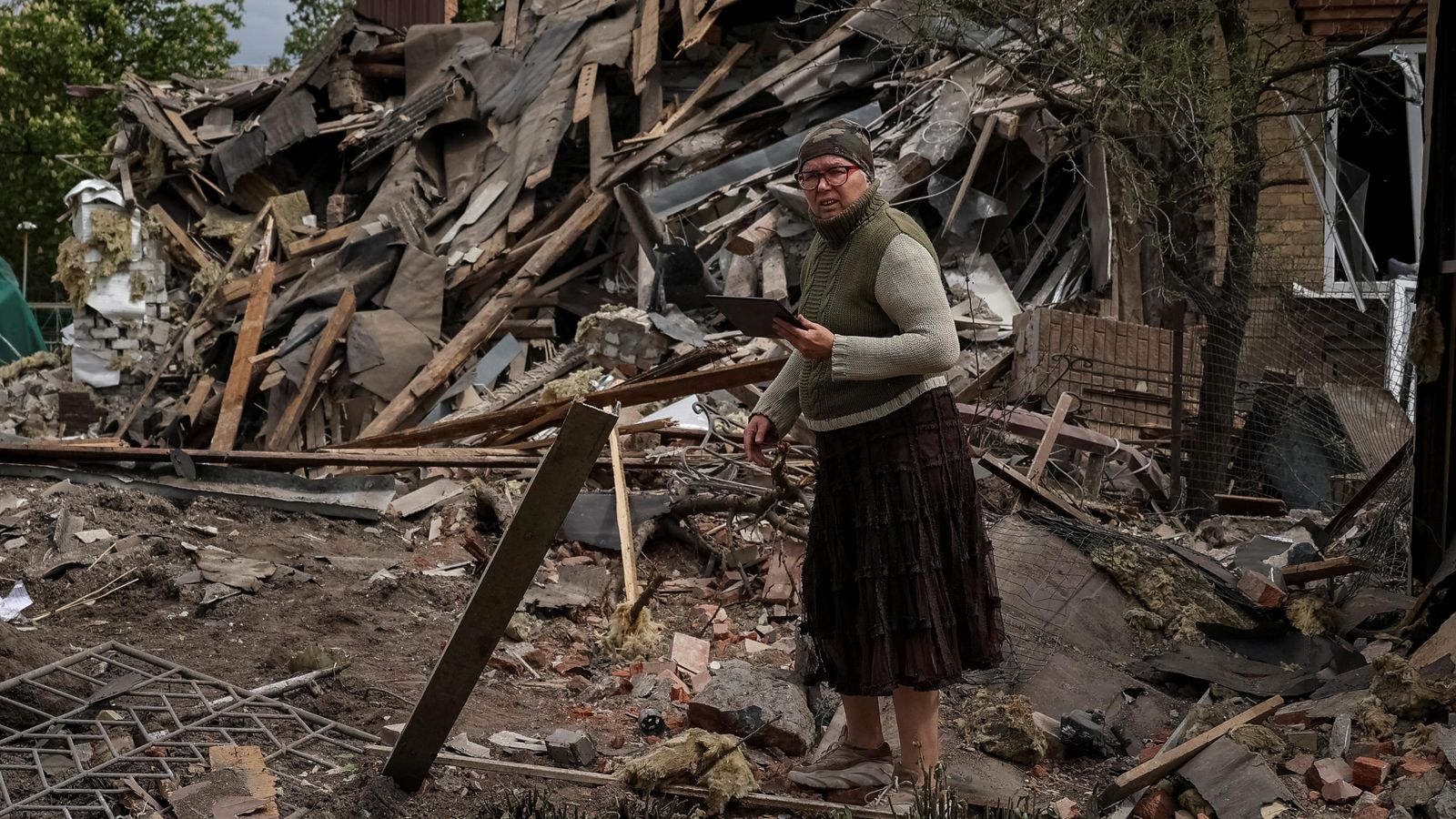 Un dona ucraïnesa es troba entre les restes d'una casa colpejada per un atac militar rus, en Sloviansk.