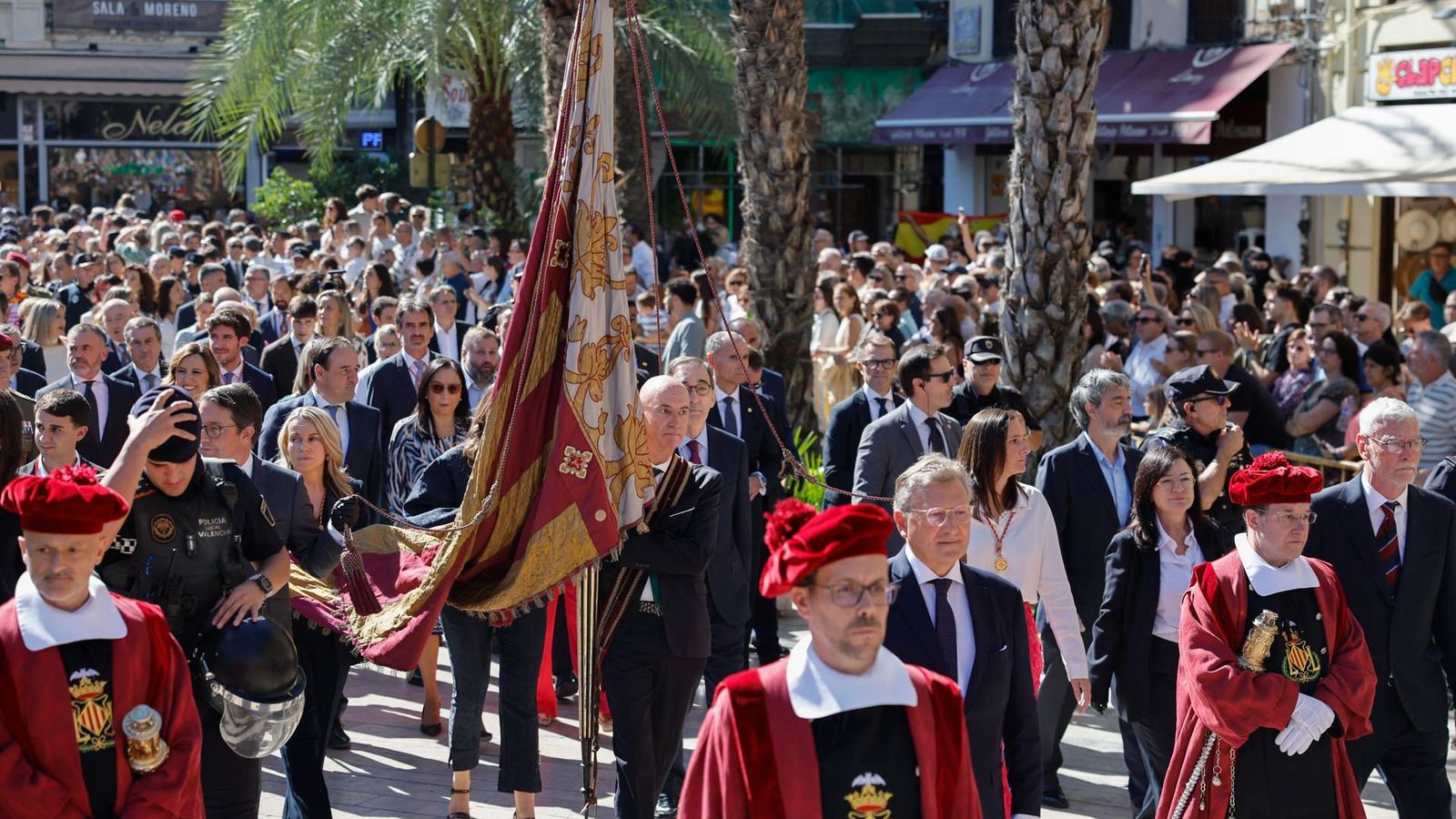 La Senyera, portada pel regidor José Gozalvez, avança per la plaça de la Reina