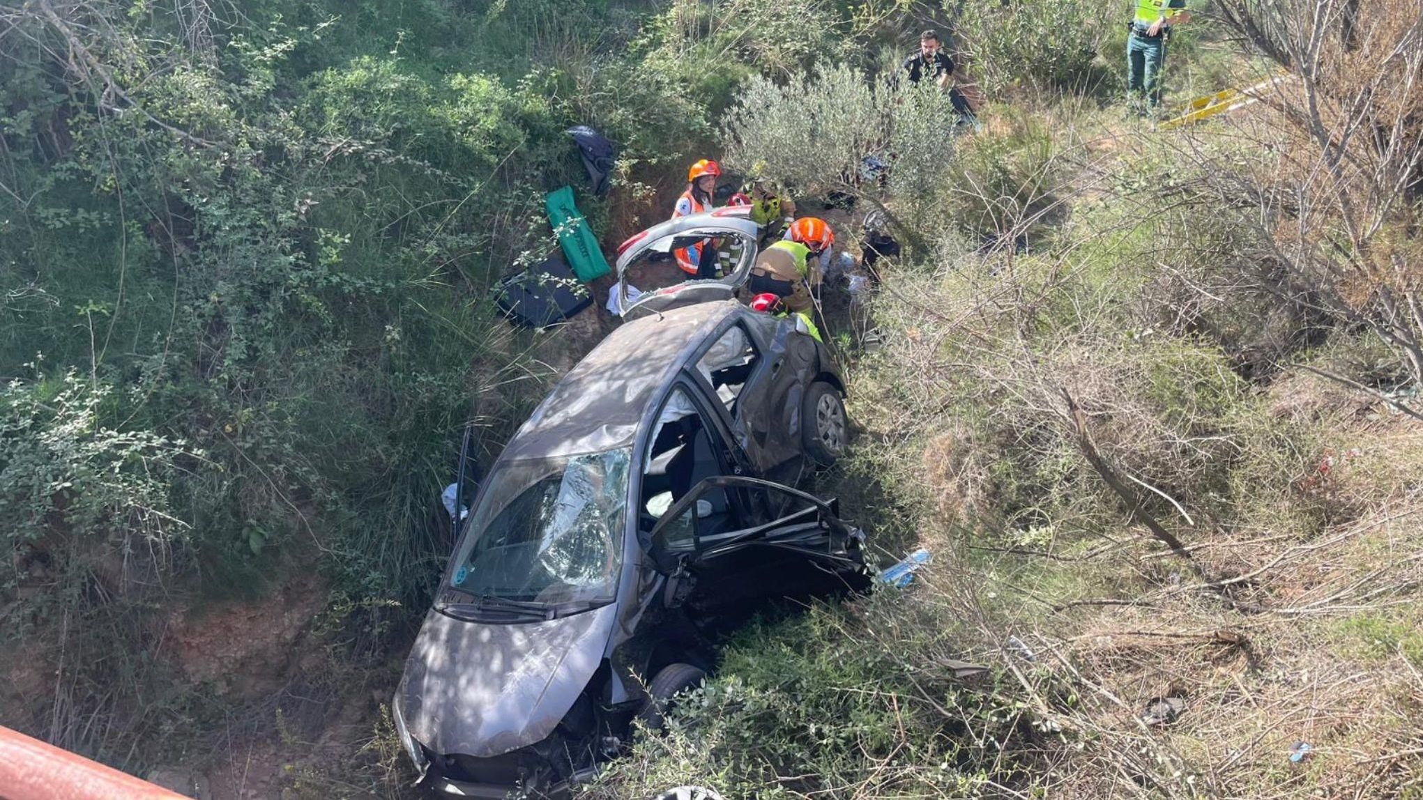 Bombers i Sanitaris treballen en l'excerceració de les tres persones atrapades en el vehicle